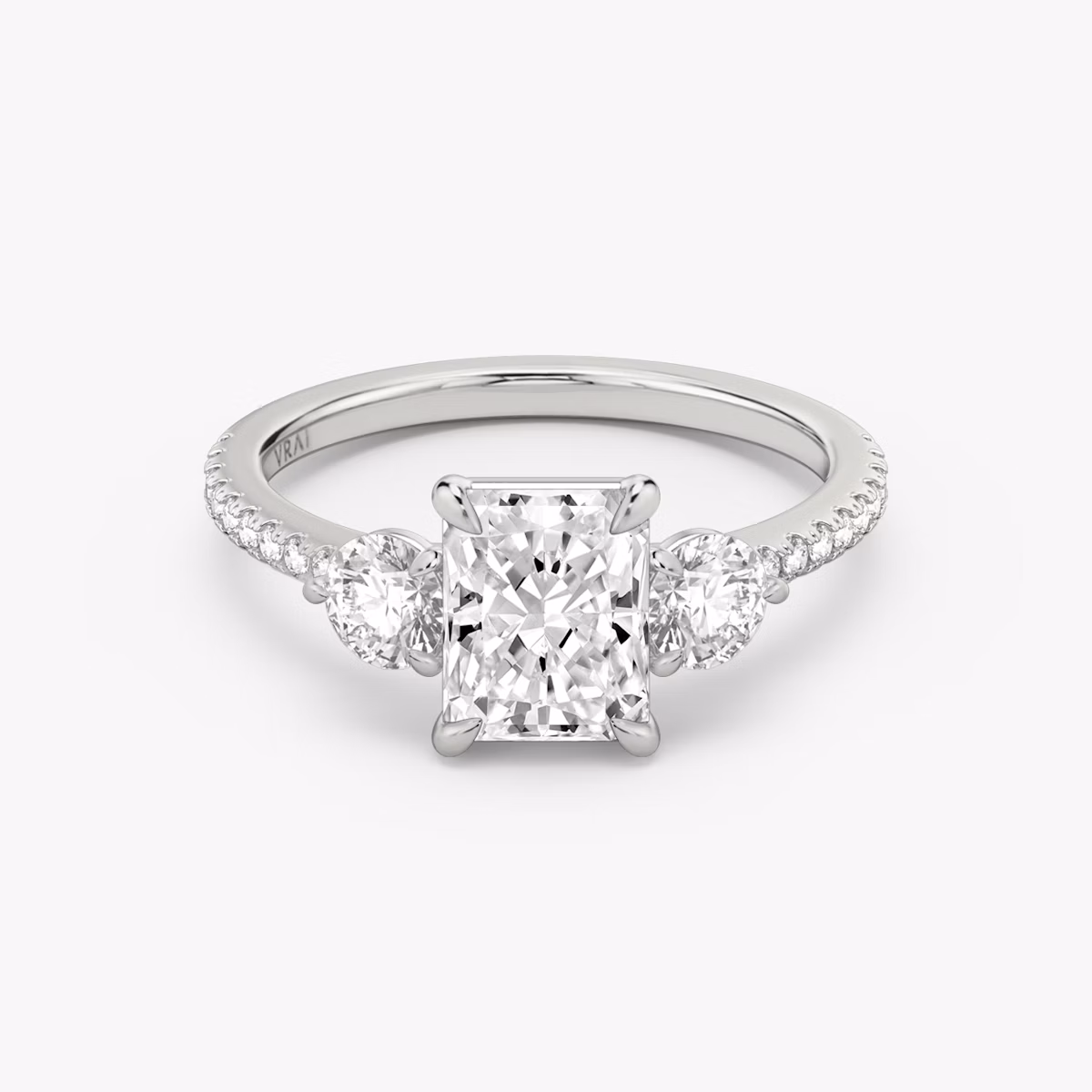 The Three Stone | Radiant | 18k | White Gold | bandAccent: Pavé | sideStoneCarat: 0.25ct | sideStoneShape: Round Brilliant | diamondOrientation: vertical | caratWeight: other