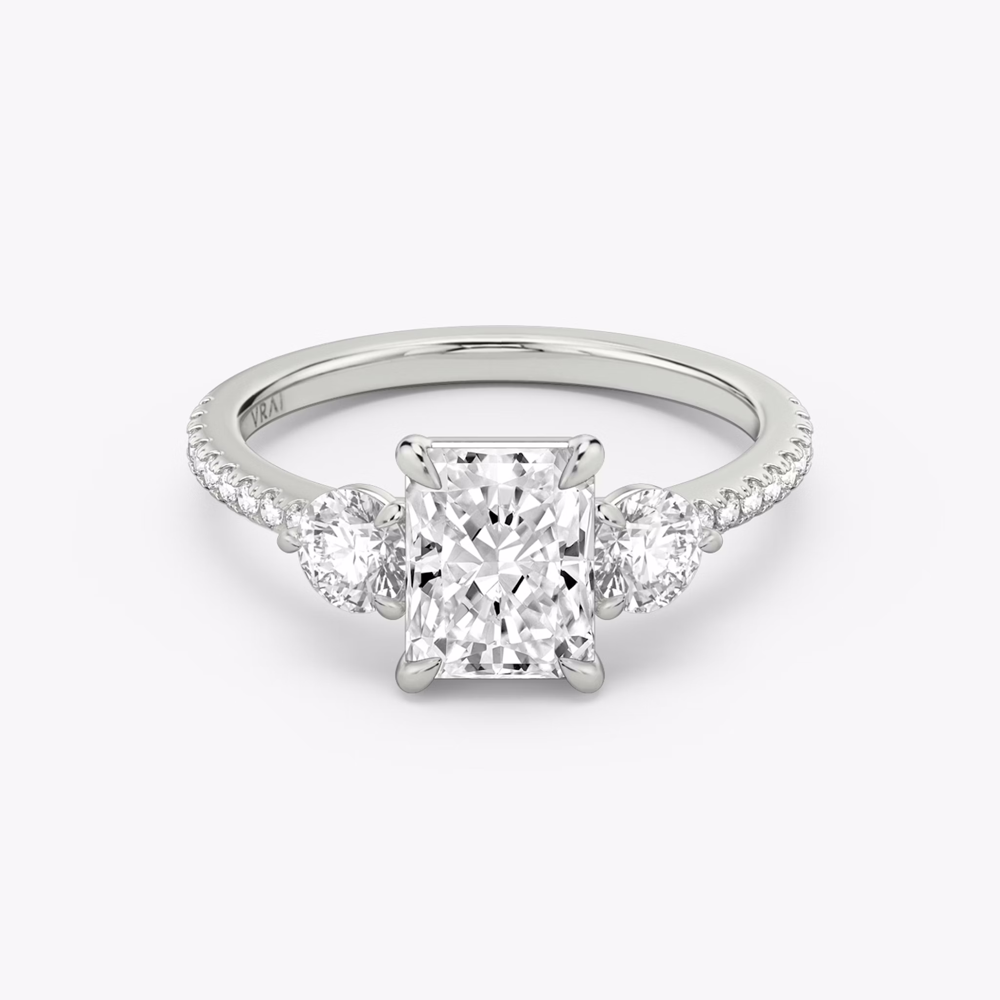 The Three Stone | Radiant | Platinum | bandAccent: Pavé | sideStoneCarat: 0.25ct | sideStoneShape: Round Brilliant | diamondOrientation: vertical | caratWeight: other