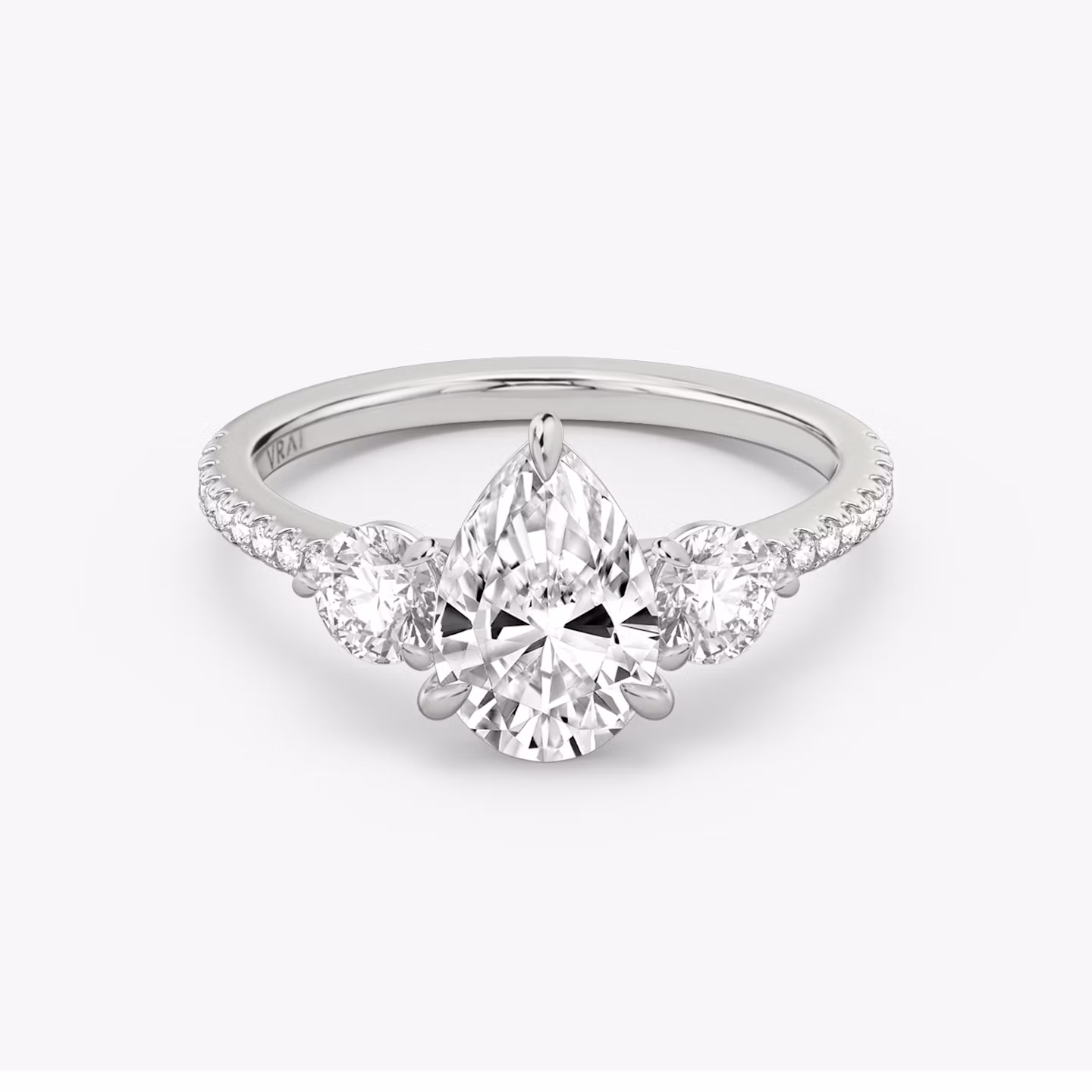 The Three Stone | Pear | Platinum | bandAccent: Pavé | sideStoneCarat: 0.25ct | sideStoneShape: Round Brilliant | diamondOrientation: vertical | caratWeight: other