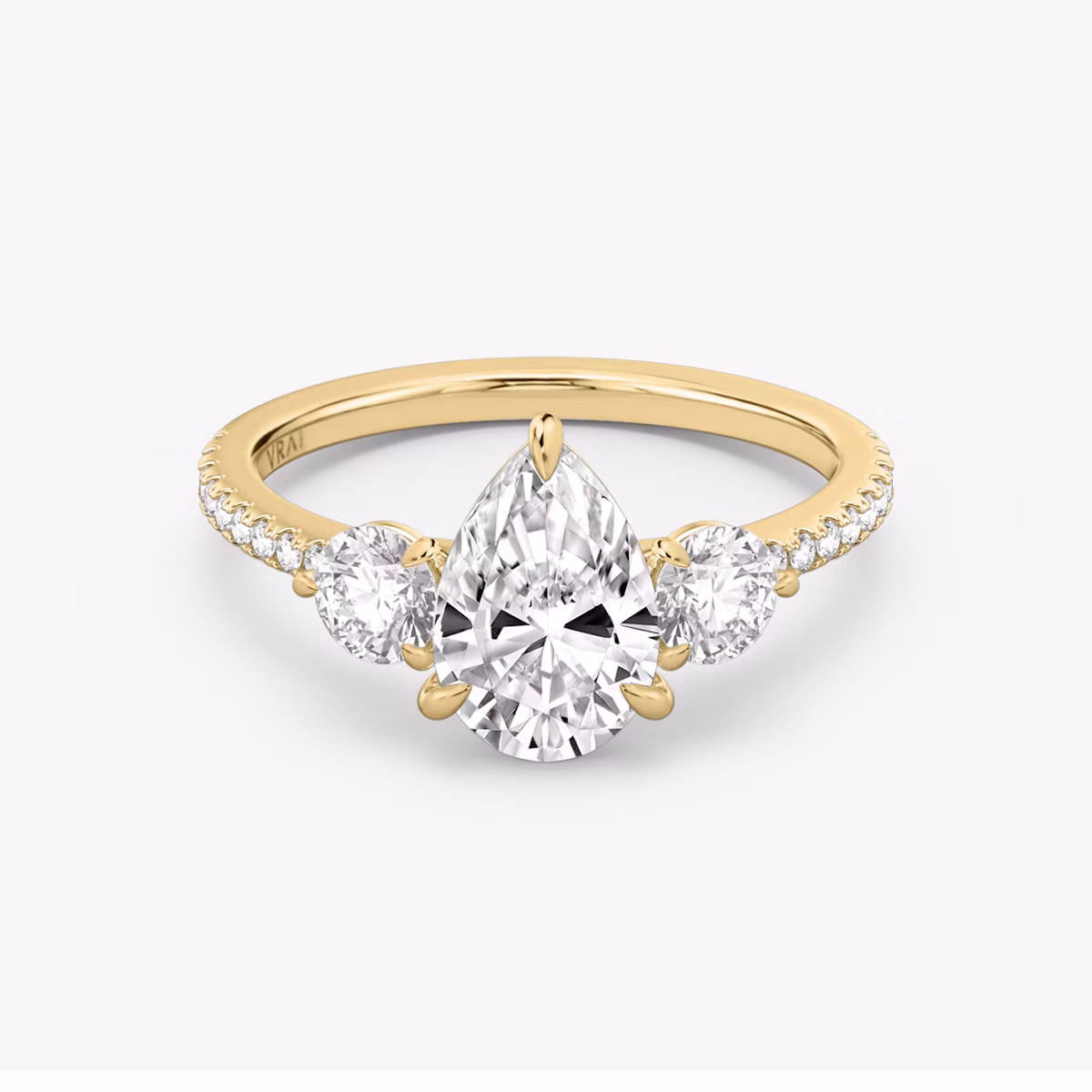 The Three Stone | Pear | 18k | Yellow Gold | bandAccent: Pavé | sideStoneCarat: 0.25ct | sideStoneShape: Round Brilliant | diamondOrientation: vertical | caratWeight: other