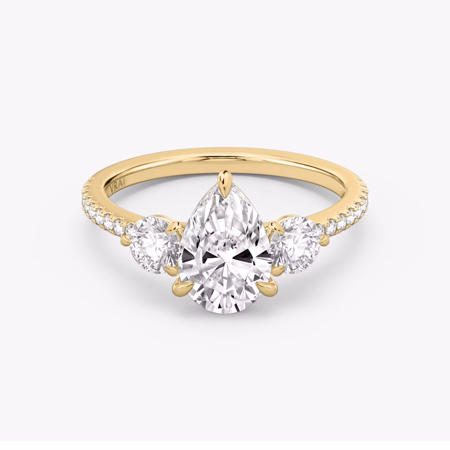 The Three Stone | Pear | 18k | Yellow Gold | bandAccent: Pavé | sideStoneCarat: 0.25ct | sideStoneShape: Round Brilliant | diamondOrientation: vertical | caratWeight: other
