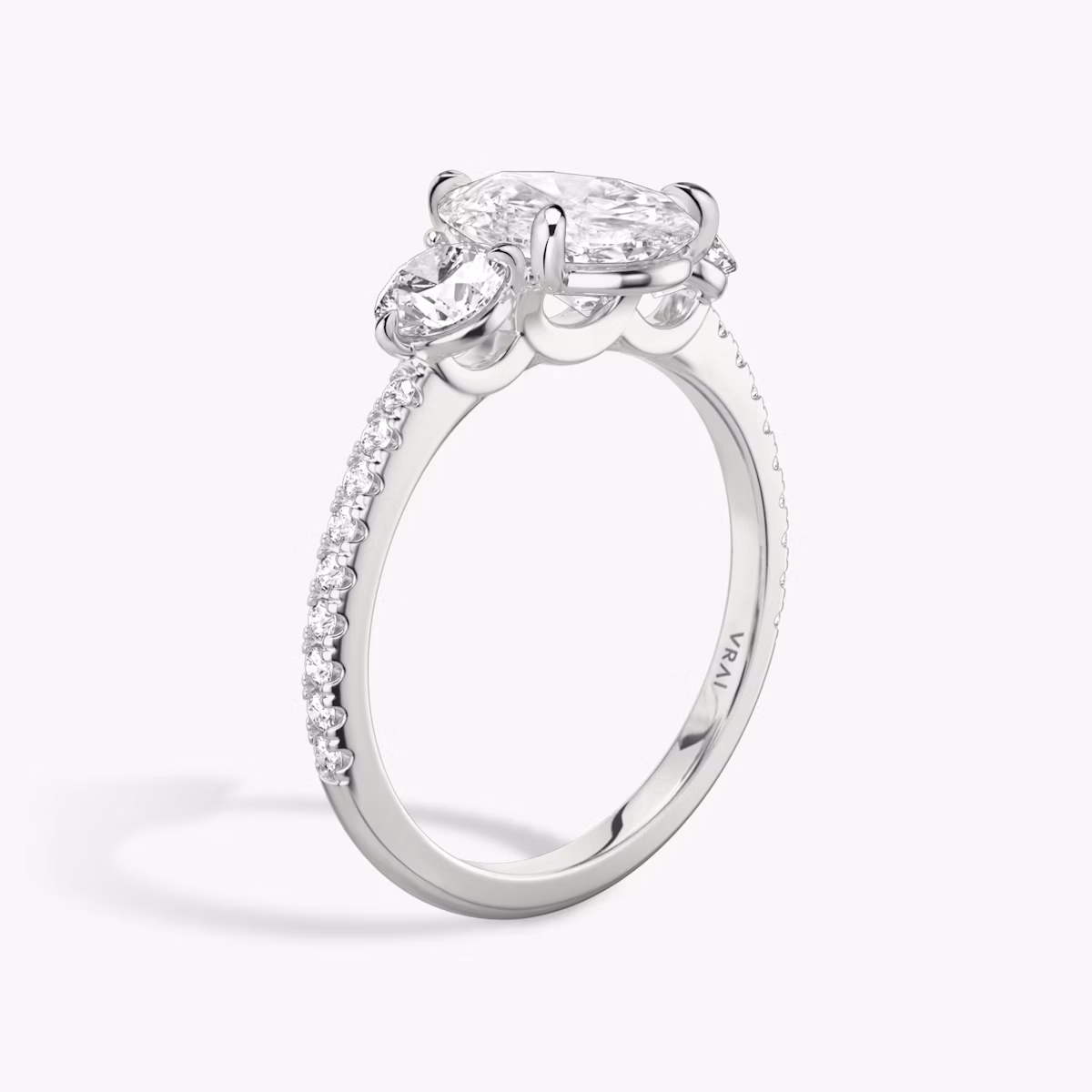 The Three Stone | Pear | Platinum | bandAccent: Pavé | sideStoneCarat: 0.25ct | sideStoneShape: Round Brilliant | diamondOrientation: vertical | caratWeight: other