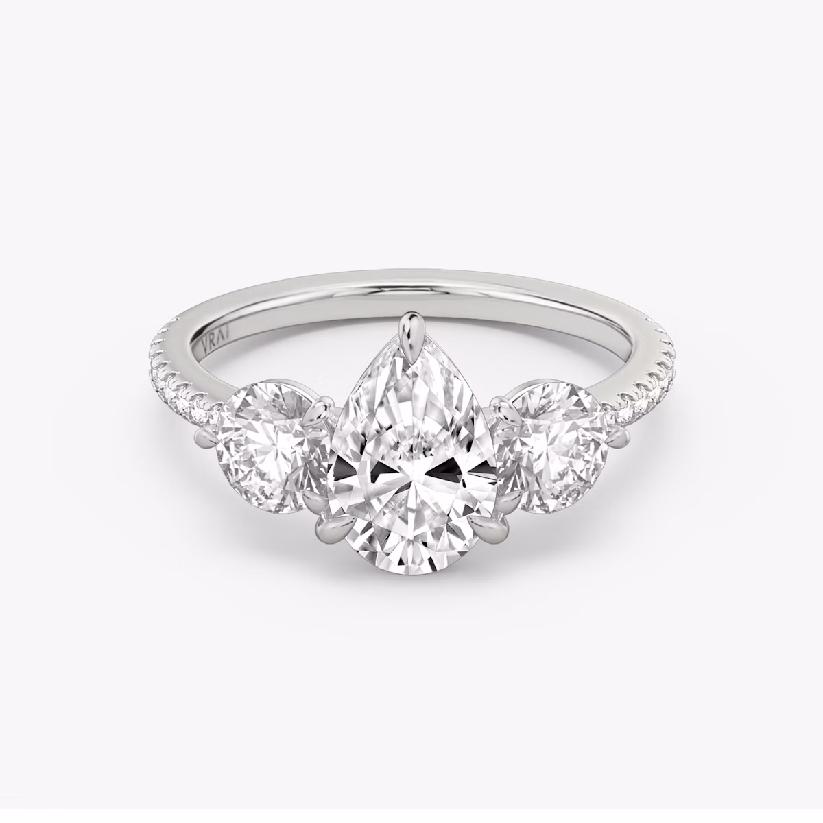 The Three Stone | Pear | Platinum | bandAccent: Pavé | sideStoneCarat: 0.50ct | sideStoneShape: Round Brilliant | diamondOrientation: vertical | caratWeight: other