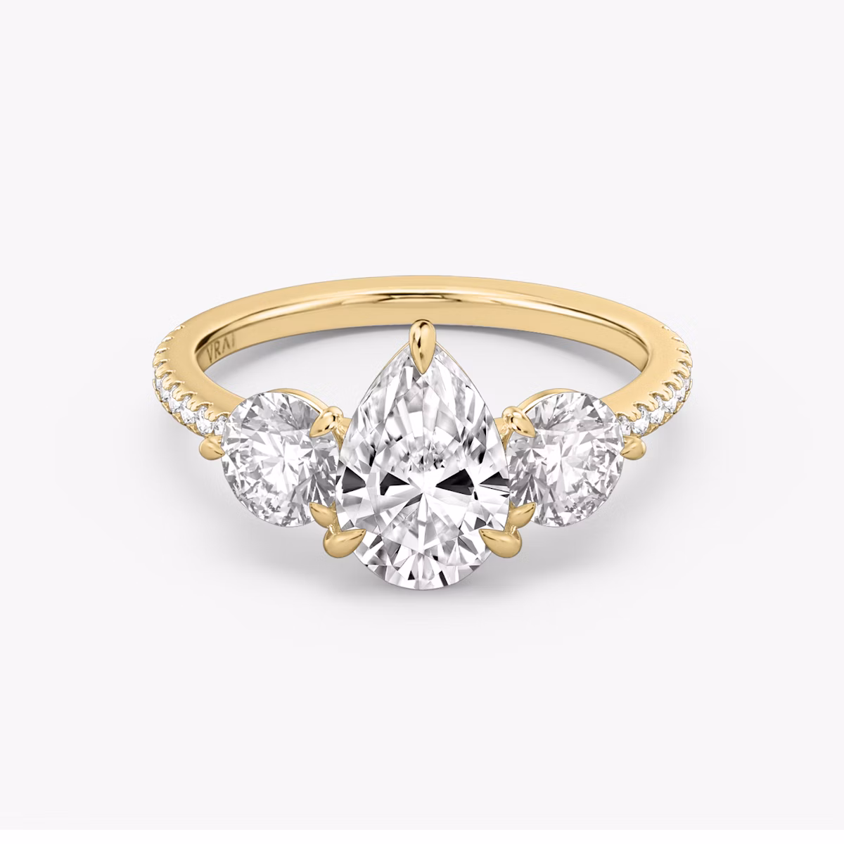 The Three Stone | Pear | 18k | Yellow Gold | bandAccent: Pavé | sideStoneCarat: 0.50ct | sideStoneShape: Round Brilliant | diamondOrientation: vertical | caratWeight: other