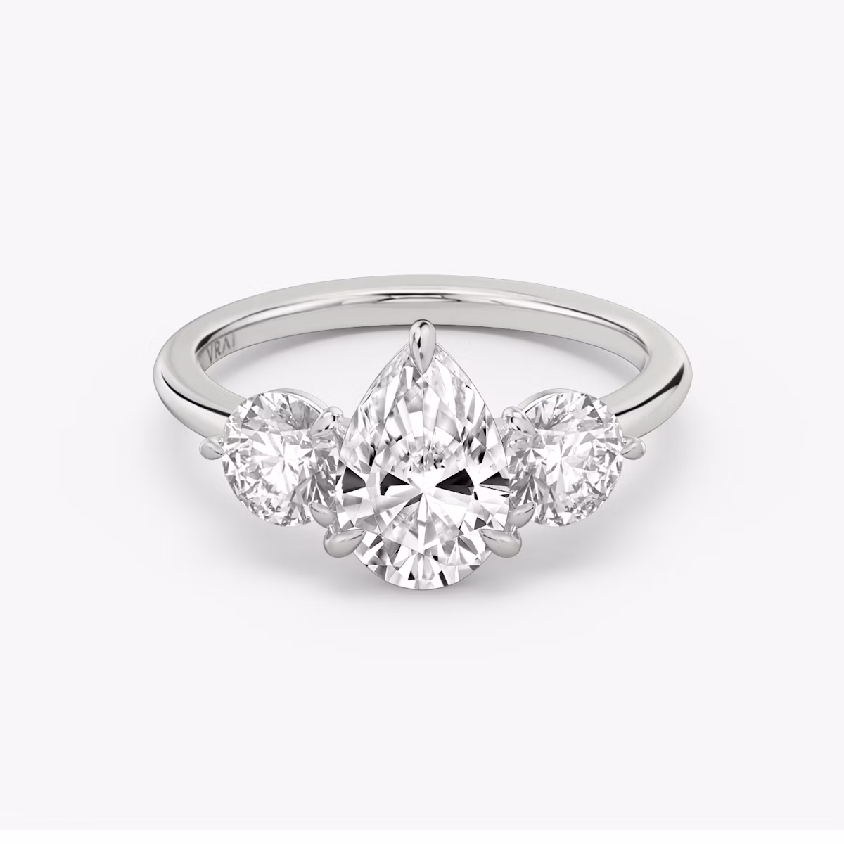 The Three Stone | Pear | Platinum | bandAccent: Plain | sideStoneCarat: 0.50ct | sideStoneShape: Round Brilliant | diamondOrientation: vertical | caratWeight: other