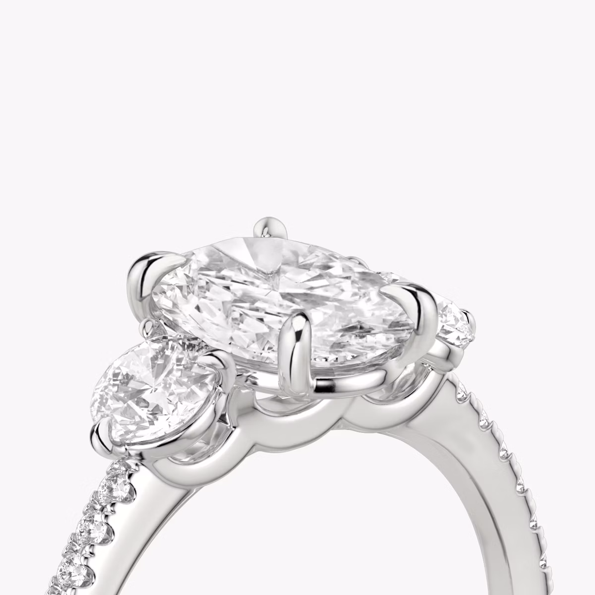 The Three Stone | Oval | 18k | White Gold | bandAccent: Pavé | sideStoneCarat: 0.25ct | sideStoneShape: Round Brilliant | diamondOrientation: vertical | caratWeight: other