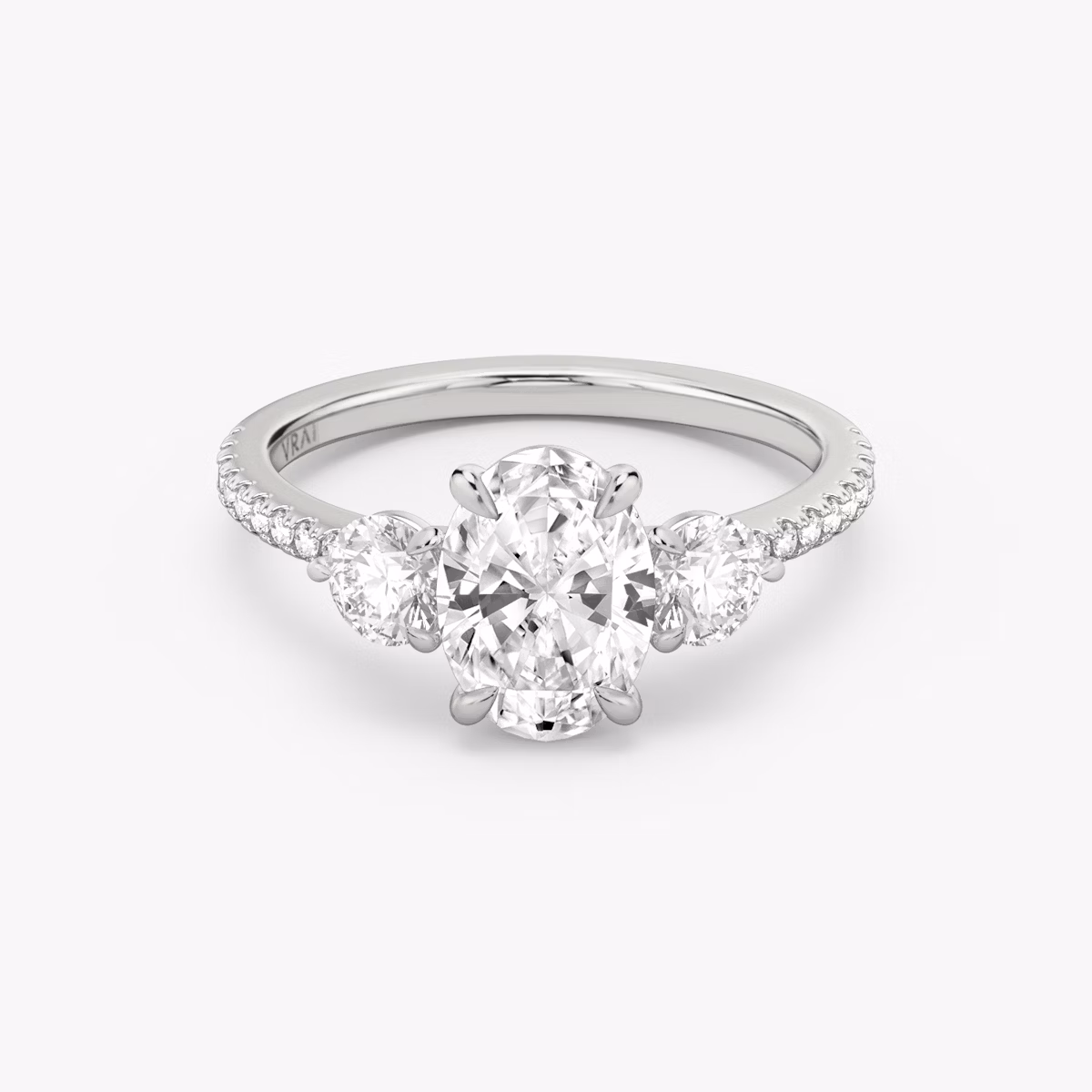 The Three Stone | Oval | 18k | White Gold | bandAccent: Pavé | sideStoneCarat: 0.25ct | sideStoneShape: Round Brilliant | diamondOrientation: vertical | caratWeight: other