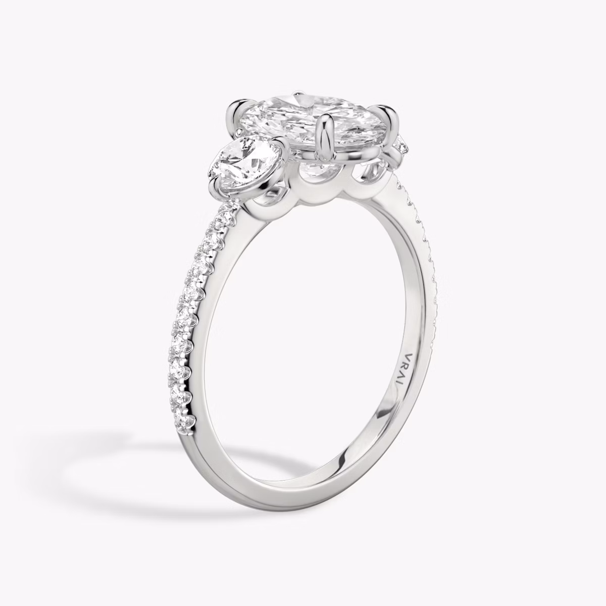 The Three Stone | Oval | 18k | White Gold | bandAccent: Pavé | sideStoneCarat: 0.25ct | sideStoneShape: Round Brilliant | diamondOrientation: vertical | caratWeight: other