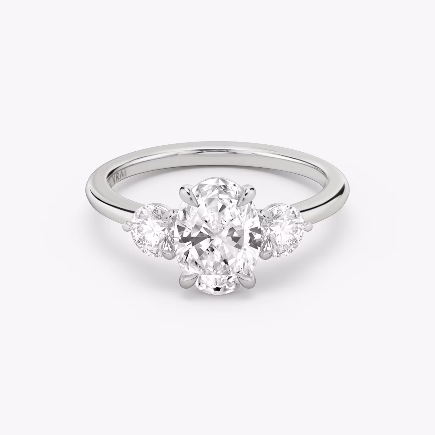 The Three Stone | Oval | 18k | White Gold | bandAccent: Plain | sideStoneCarat: 0.25ct | sideStoneShape: Round Brilliant | diamondOrientation: vertical | caratWeight: other