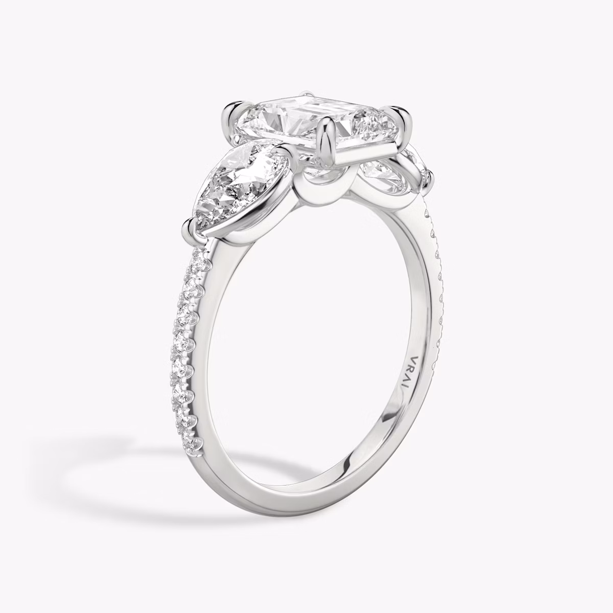 The Three Stone | Radiant | Platinum | bandAccent: Pavé | sideStoneCarat: 0.50ct | sideStoneShape: Pear | diamondOrientation: vertical | caratWeight: other