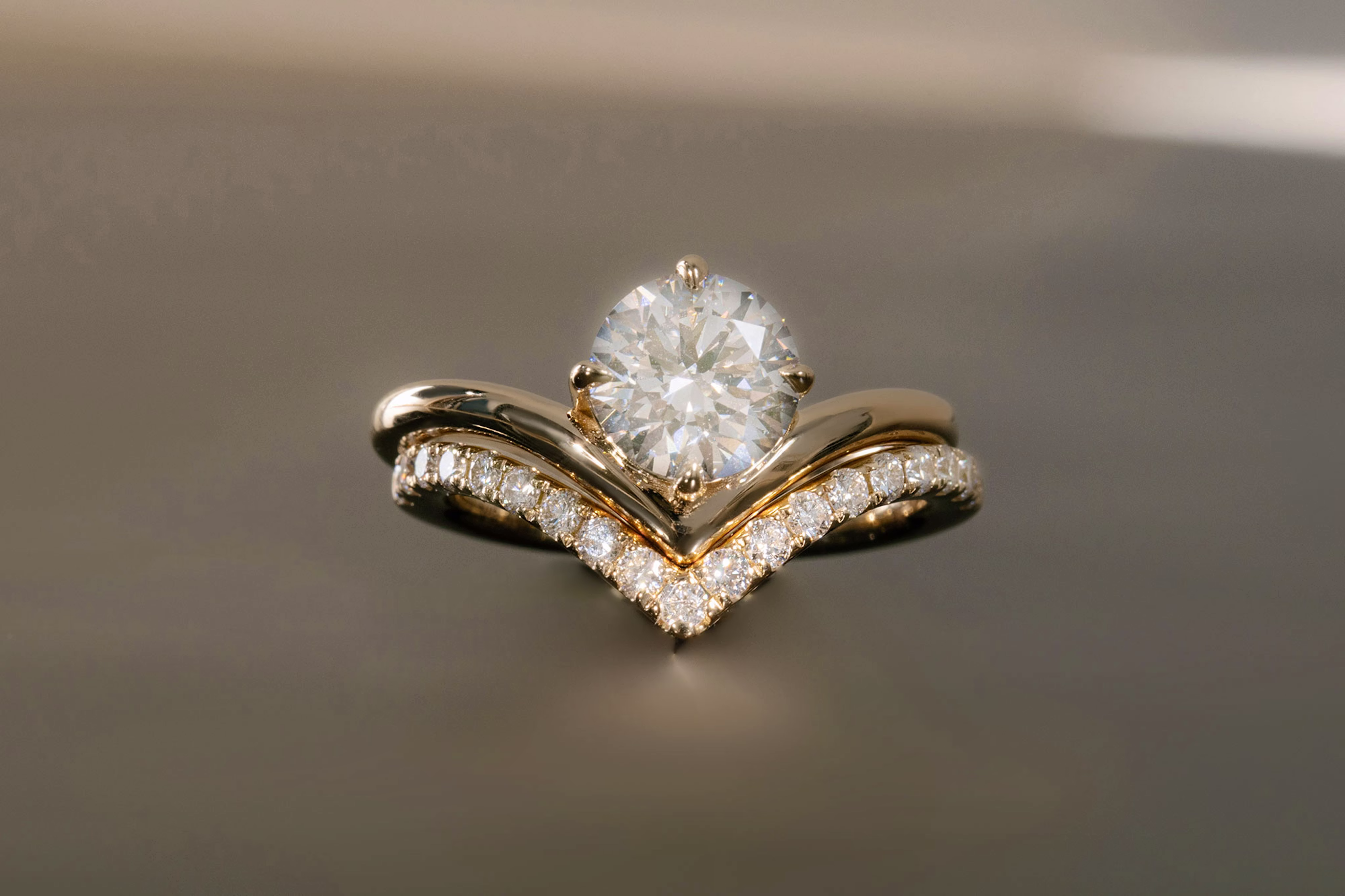 The round brilliant signature v engagement ring with yellow gold band