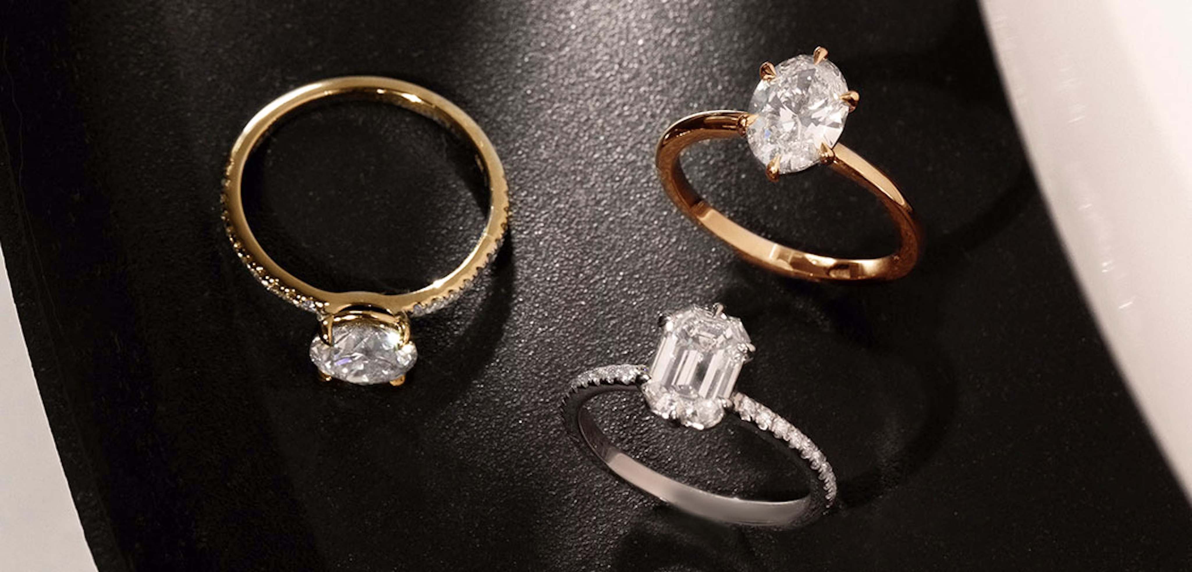 Round brilliant engagement ring with yellow gold pave band, signature 6 prong oval engagement ring with rose gold pave band, signature emerald engagement ring with white gold pave band