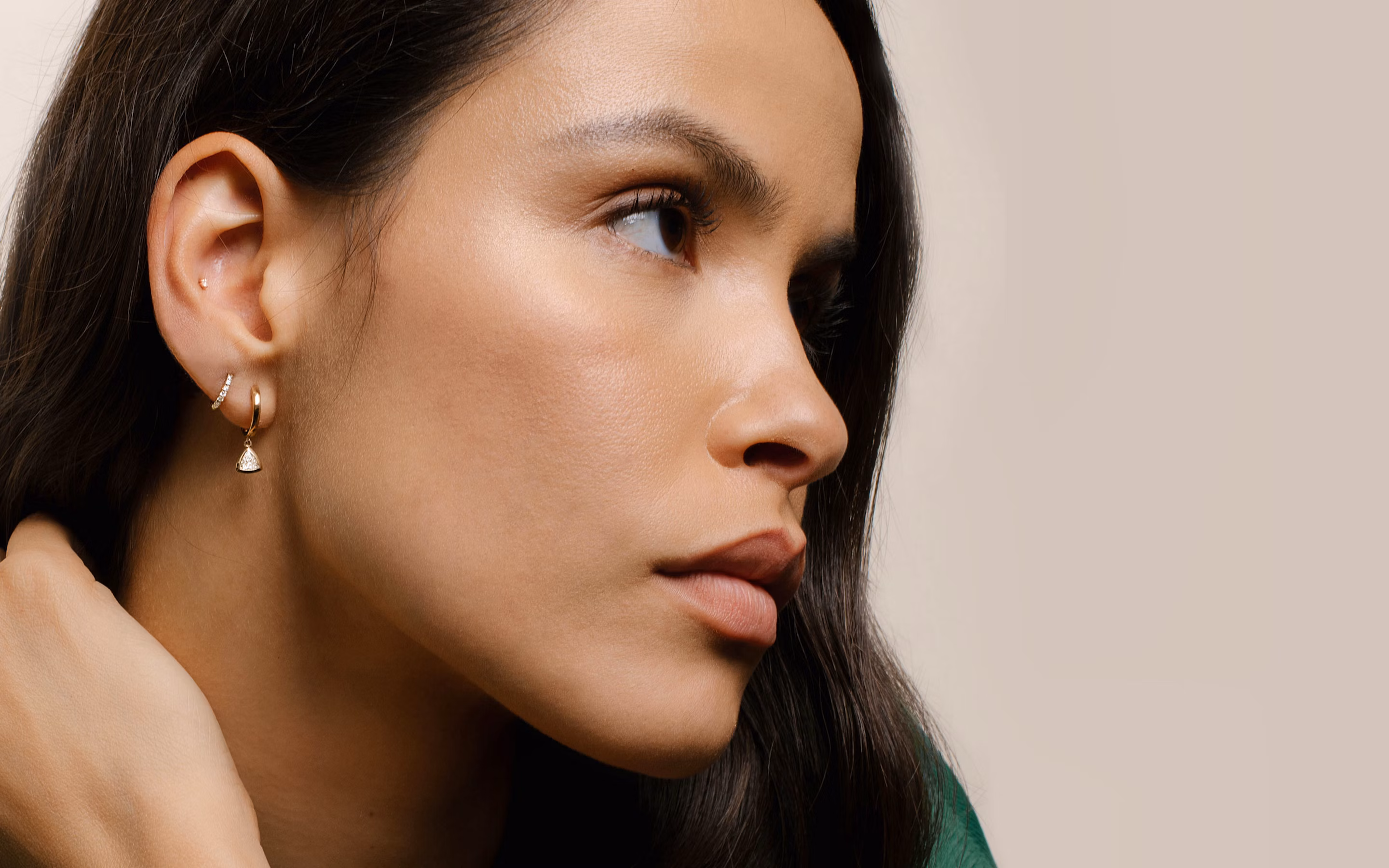 Model wearing earrings, huggies hoops, drop huggie hoops
