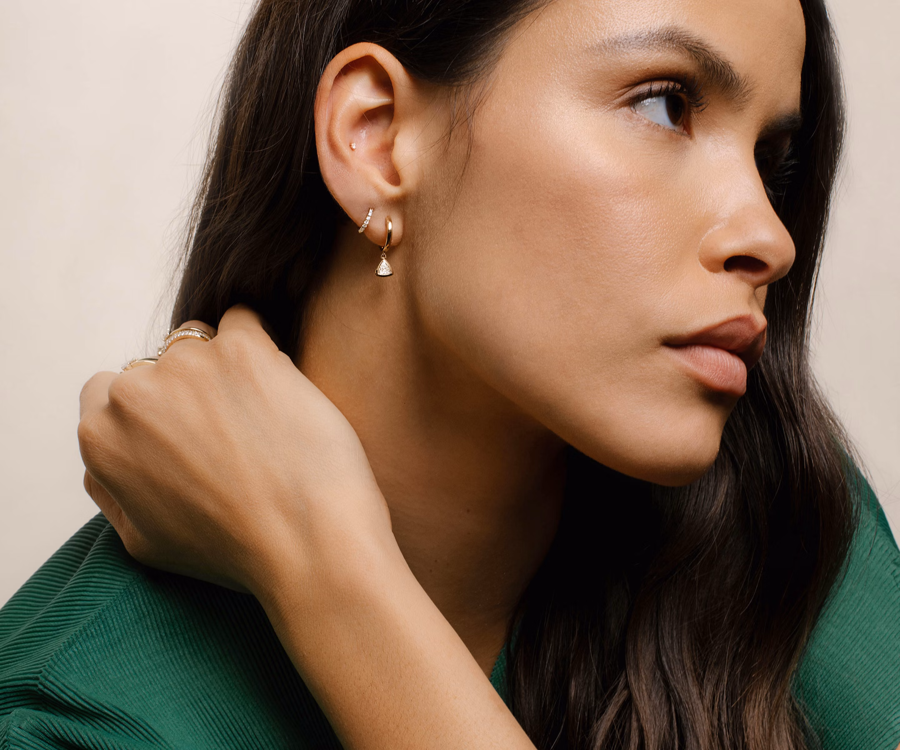 Model wearing earrings, huggies hoops, drop huggie hoops