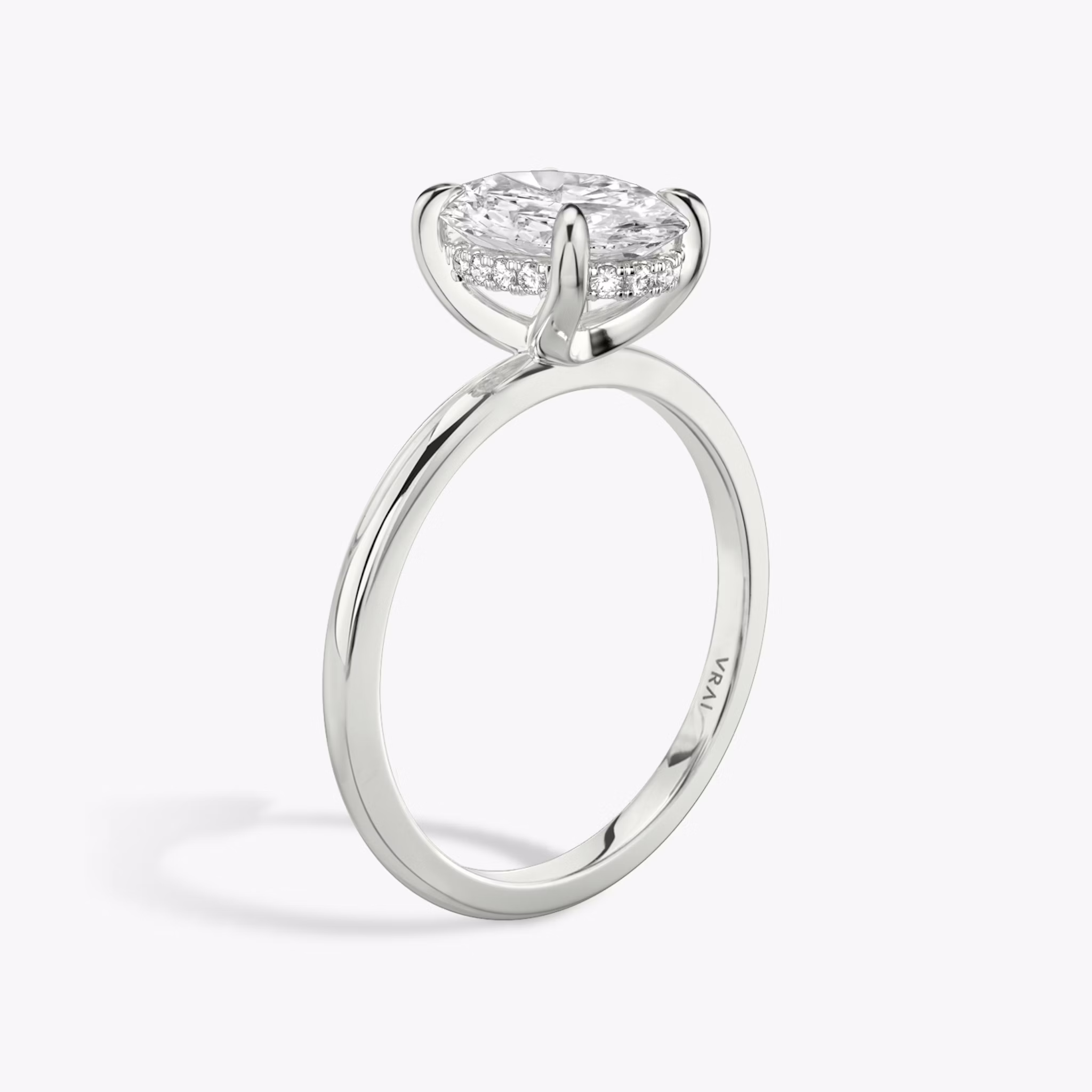 Oval-cut diamond engagement ring with hidden halo on white gold band, shown in side profile on white background.