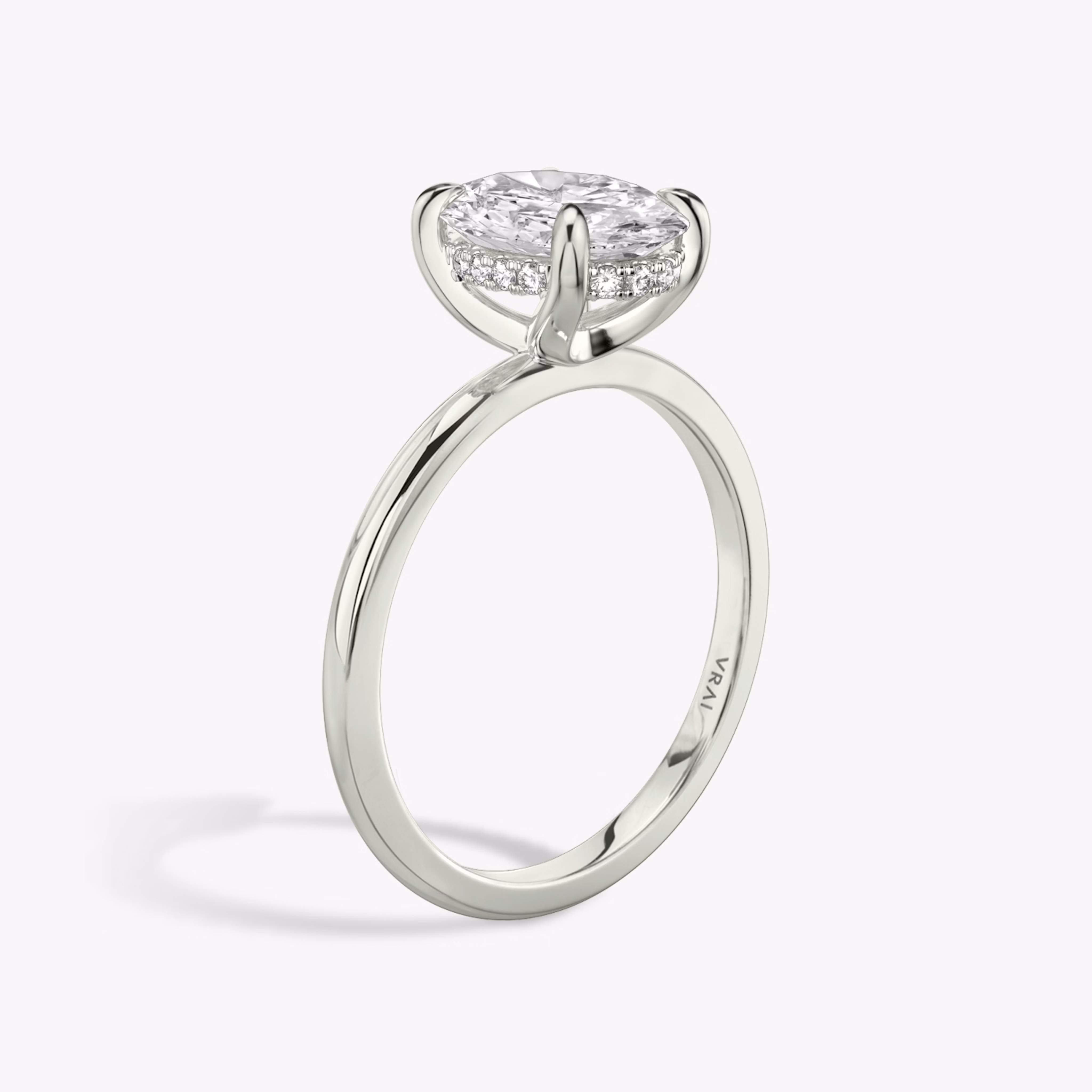 Oval-cut diamond engagement ring with hidden halo on white gold band, shown in side profile on white background.