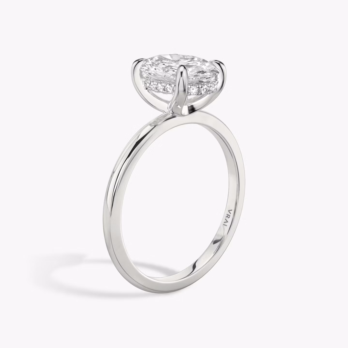 Oval-cut diamond engagement ring with hidden halo on white gold band, shown in side profile on white background.