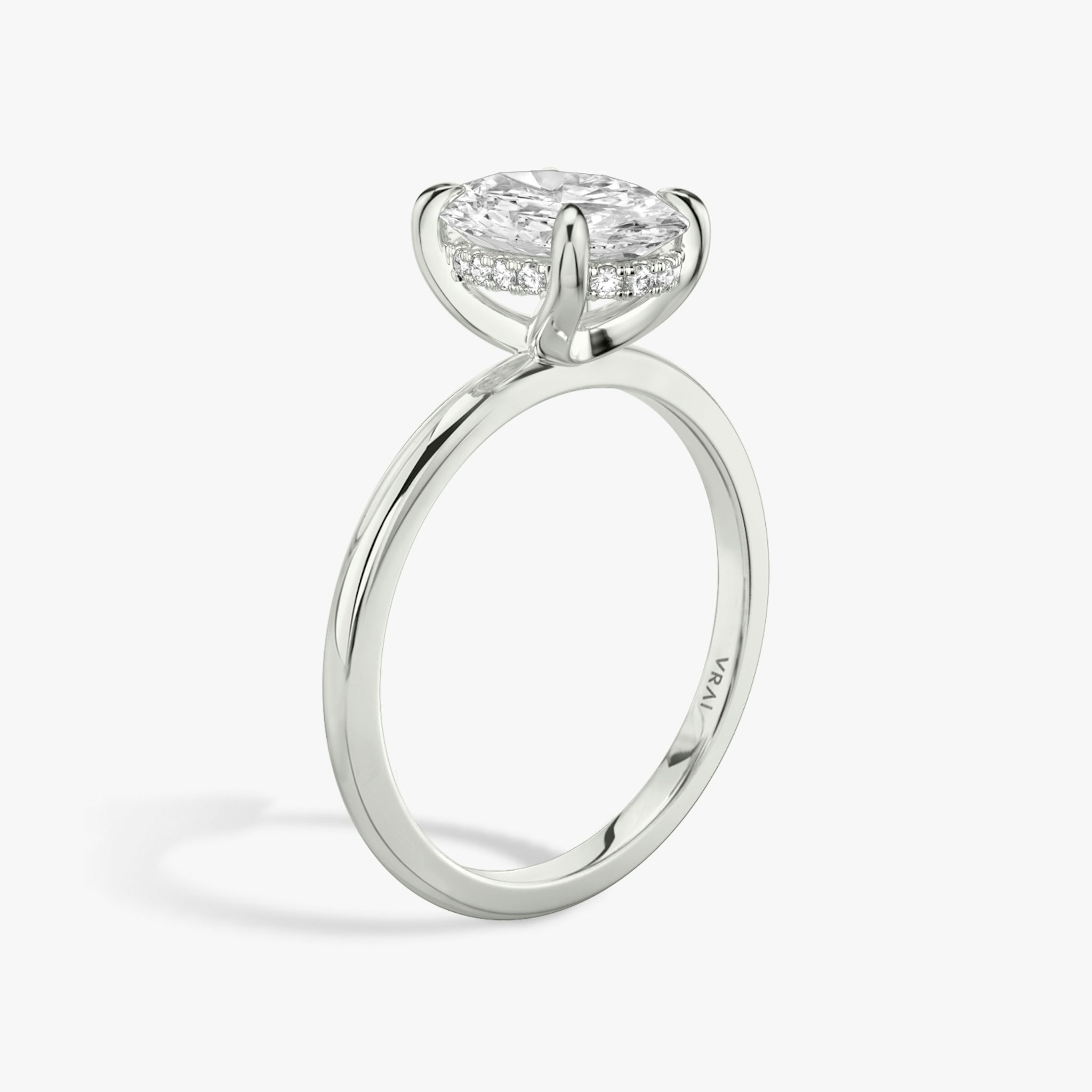 Oval-cut diamond engagement ring with hidden halo on white gold band, shown in side profile on white background.