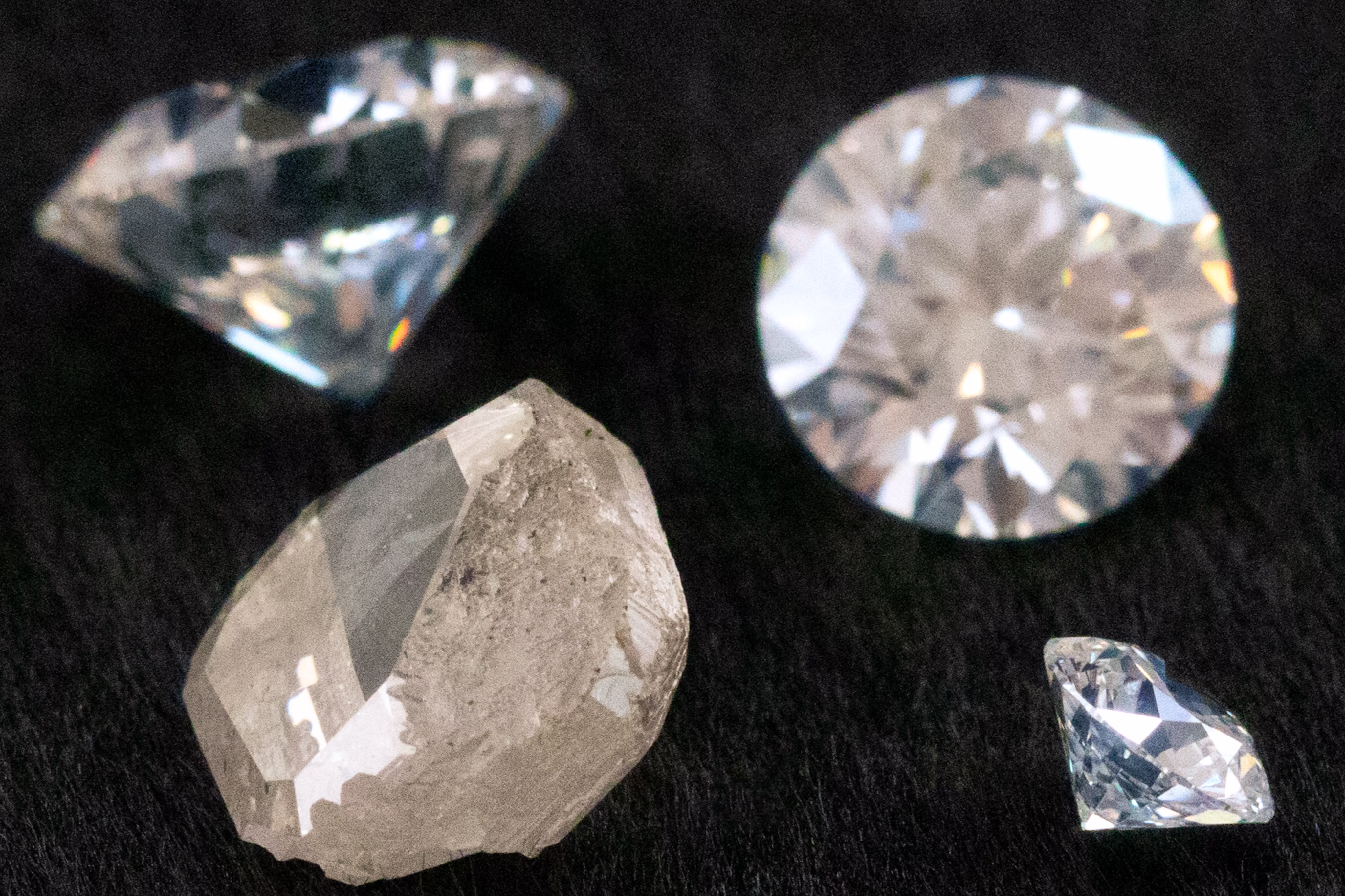An image showing rough, uncut diamonds and finished, polished diamonds, showcasing different stages of the diamond manufacturing process.