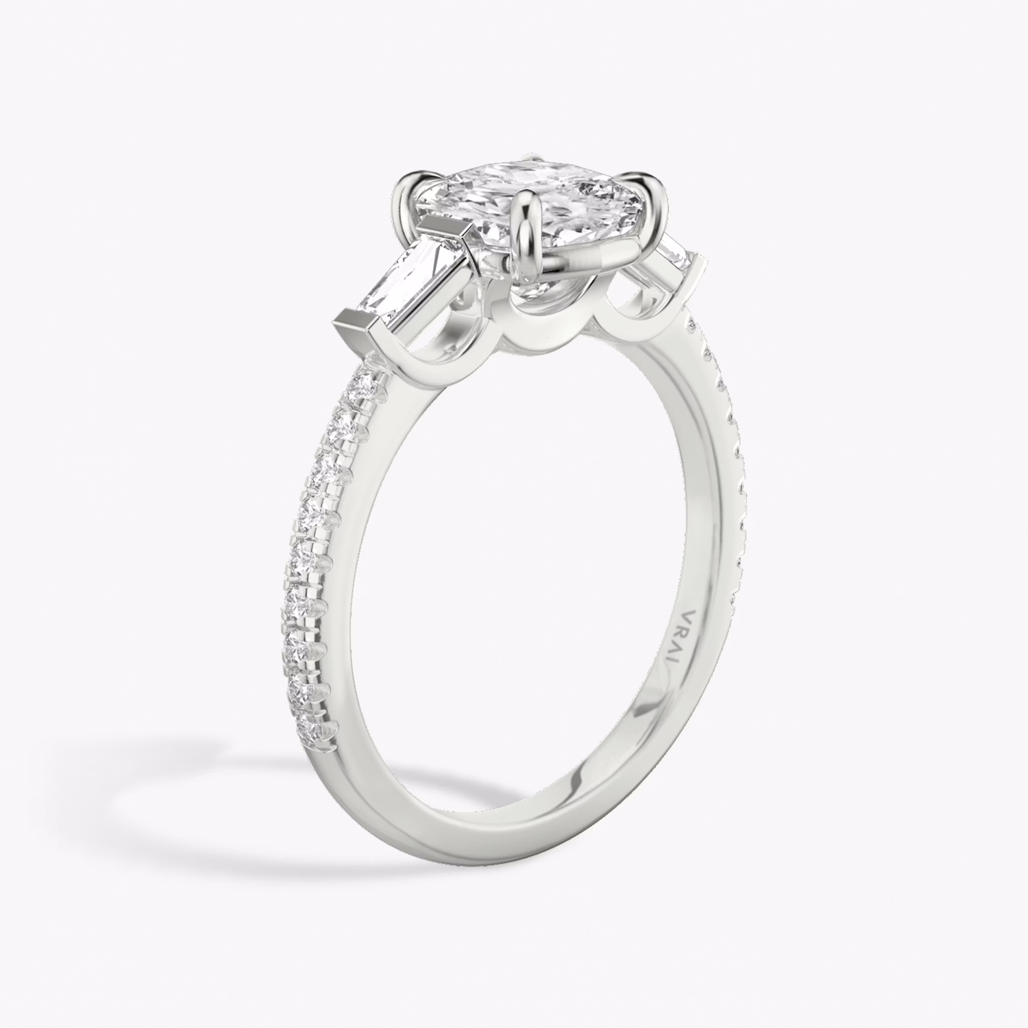 The Three Stone | Cushion | 18k | White Gold | bandAccent: Pavé | sideStoneCarat: 0.10ct | sideStoneShape: Tapered Baguette | diamondOrientation: vertical | caratWeight: other