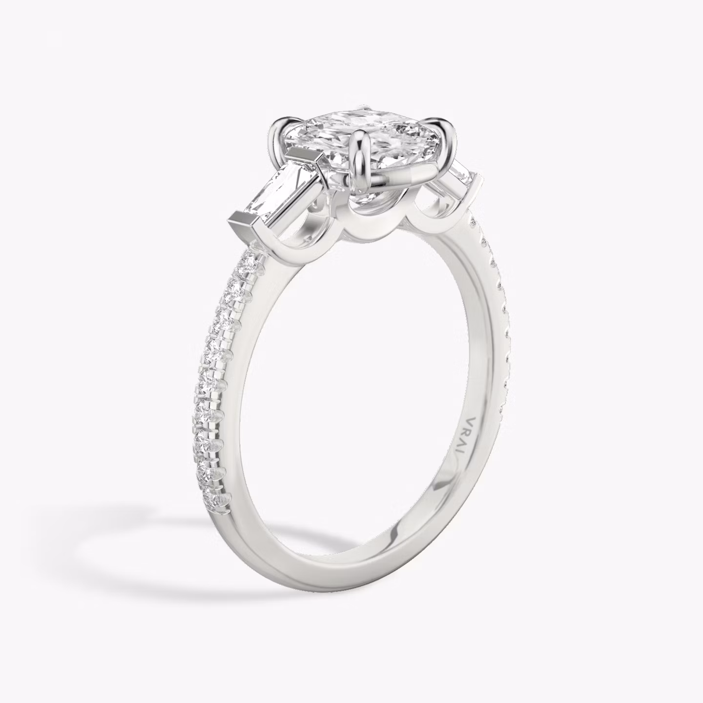 The Three Stone | Cushion | 18k | White Gold | bandAccent: Pavé | sideStoneCarat: 0.10ct | sideStoneShape: Tapered Baguette | diamondOrientation: vertical | caratWeight: other