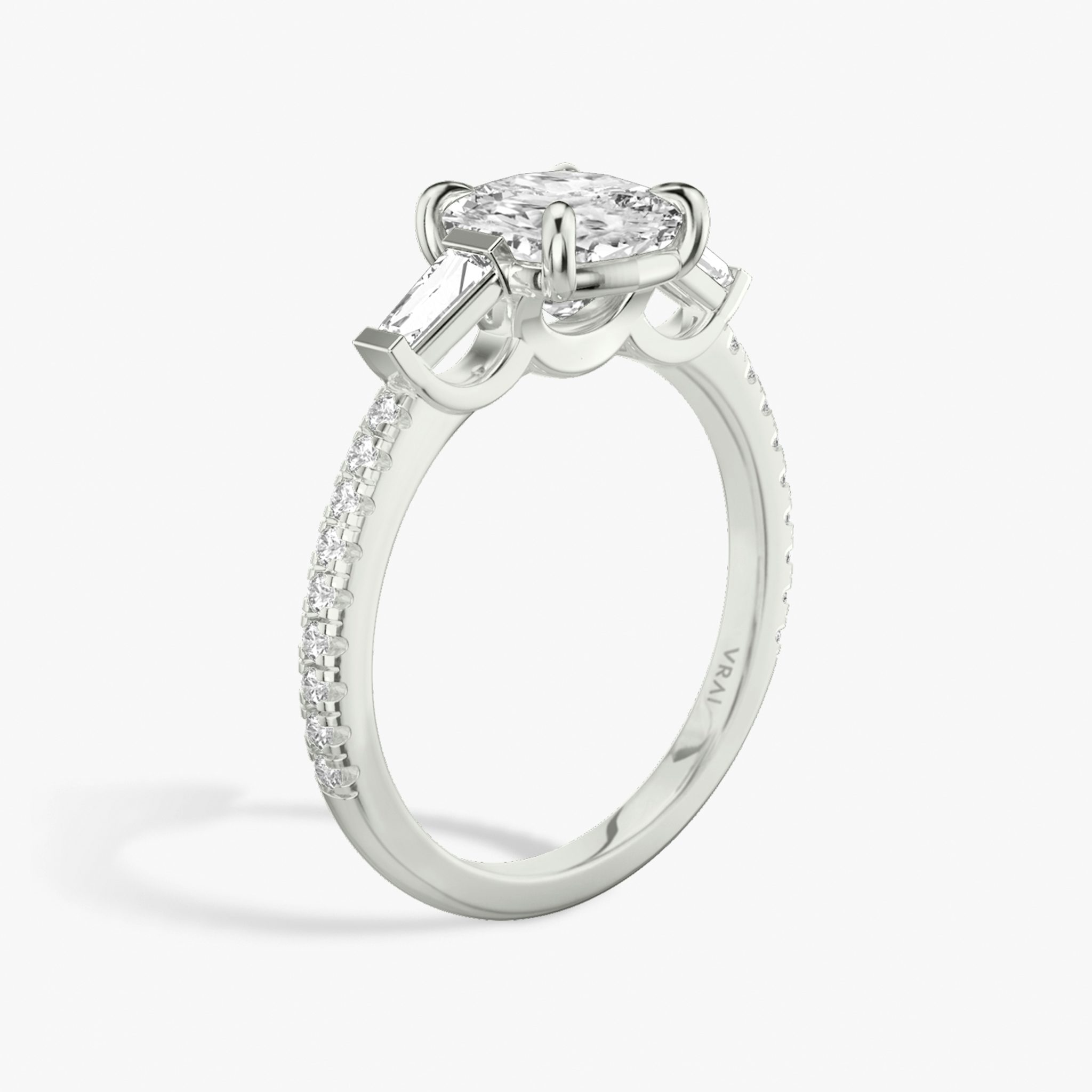 The Three Stone | Cushion | 18k | White Gold | bandAccent: Pavé | sideStoneCarat: 0.10ct | sideStoneShape: Tapered Baguette | diamondOrientation: vertical | caratWeight: other