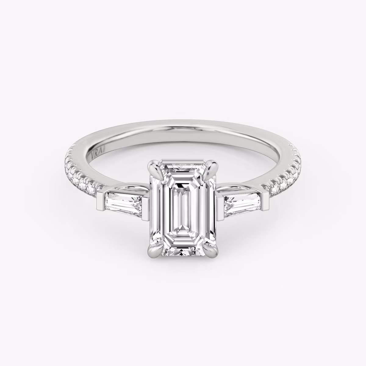 The Three Stone | Emerald | Platinum | bandAccent: Pavé | sideStoneCarat: 0.10ct | sideStoneShape: Tapered Baguette | diamondOrientation: vertical | caratWeight: other