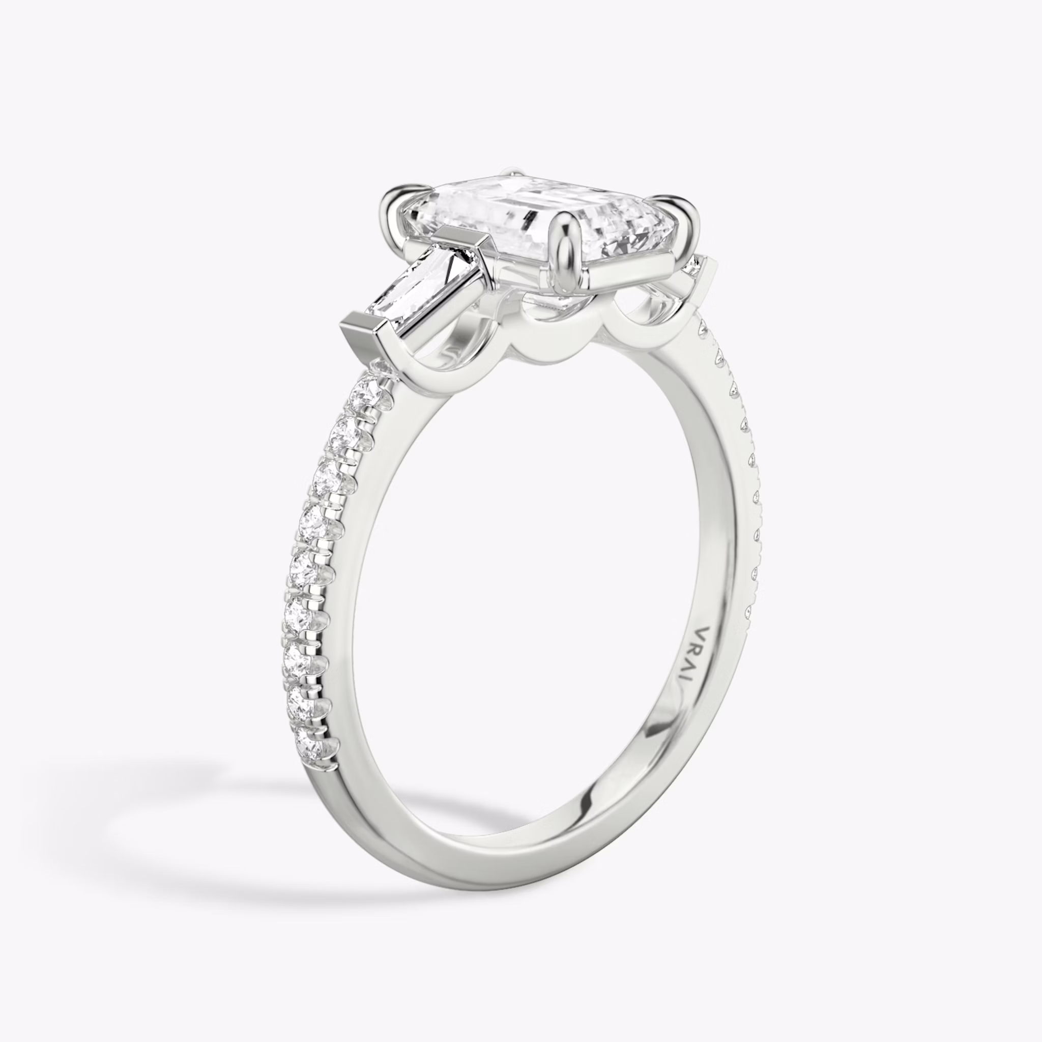 The Three Stone | Emerald | 18k | White Gold | bandAccent: Pavé | sideStoneCarat: 0.10ct | sideStoneShape: Tapered Baguette | diamondOrientation: vertical | caratWeight: other