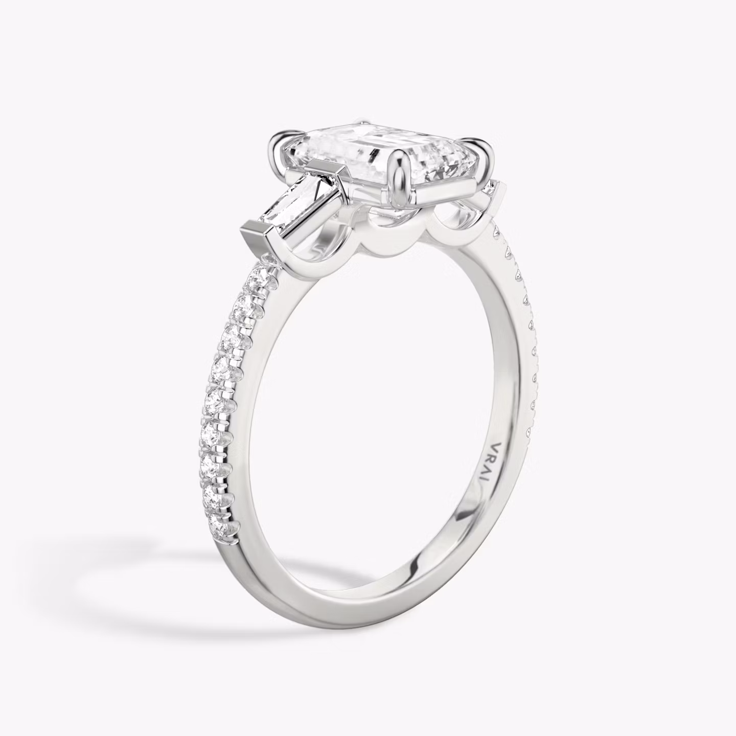 The Three Stone | Emerald | 18k | White Gold | bandAccent: Pavé | sideStoneCarat: 0.10ct | sideStoneShape: Tapered Baguette | diamondOrientation: vertical | caratWeight: other