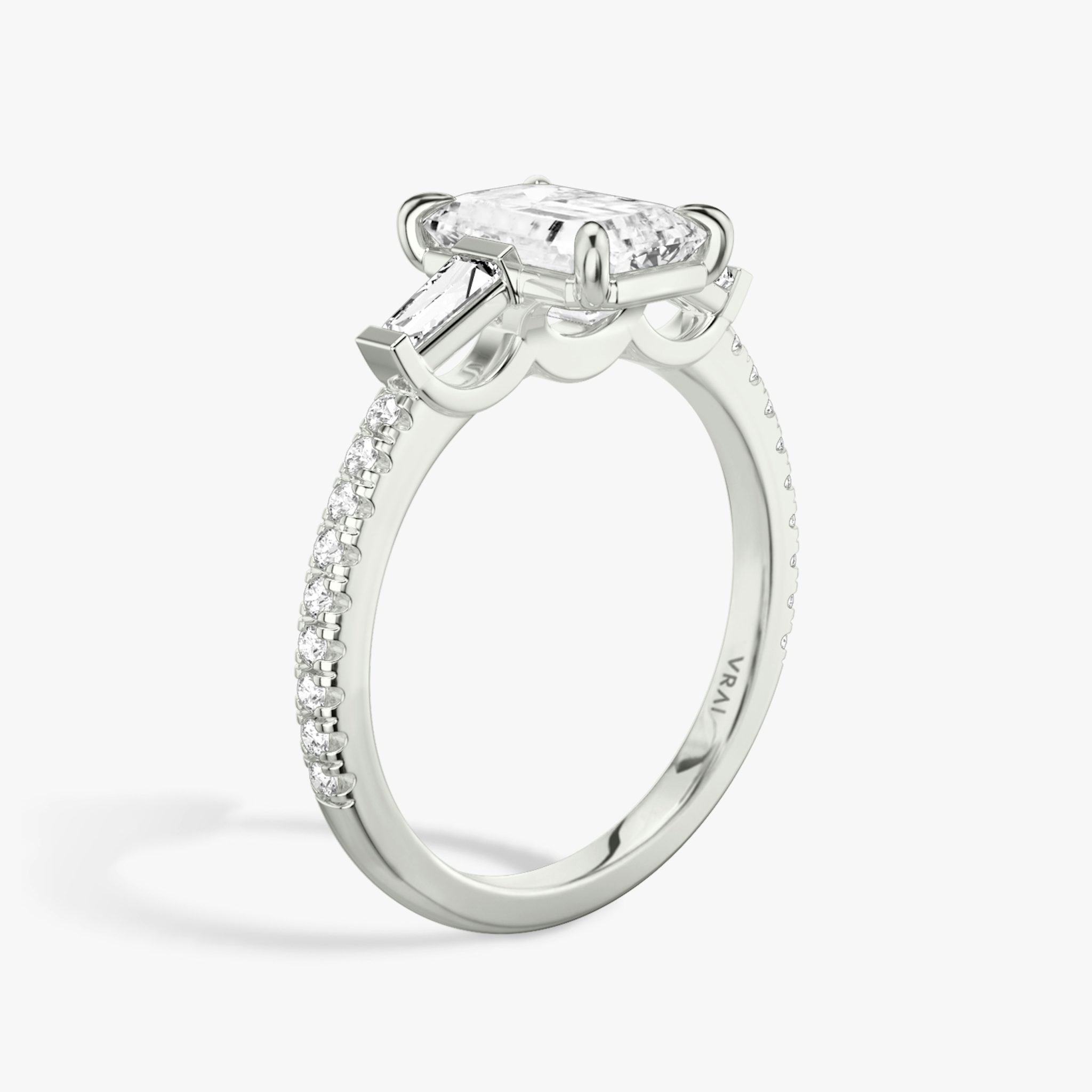 The Three Stone | Emerald | 18k | White Gold | bandAccent: Pavé | sideStoneCarat: 0.10ct | sideStoneShape: Tapered Baguette | diamondOrientation: vertical | caratWeight: other