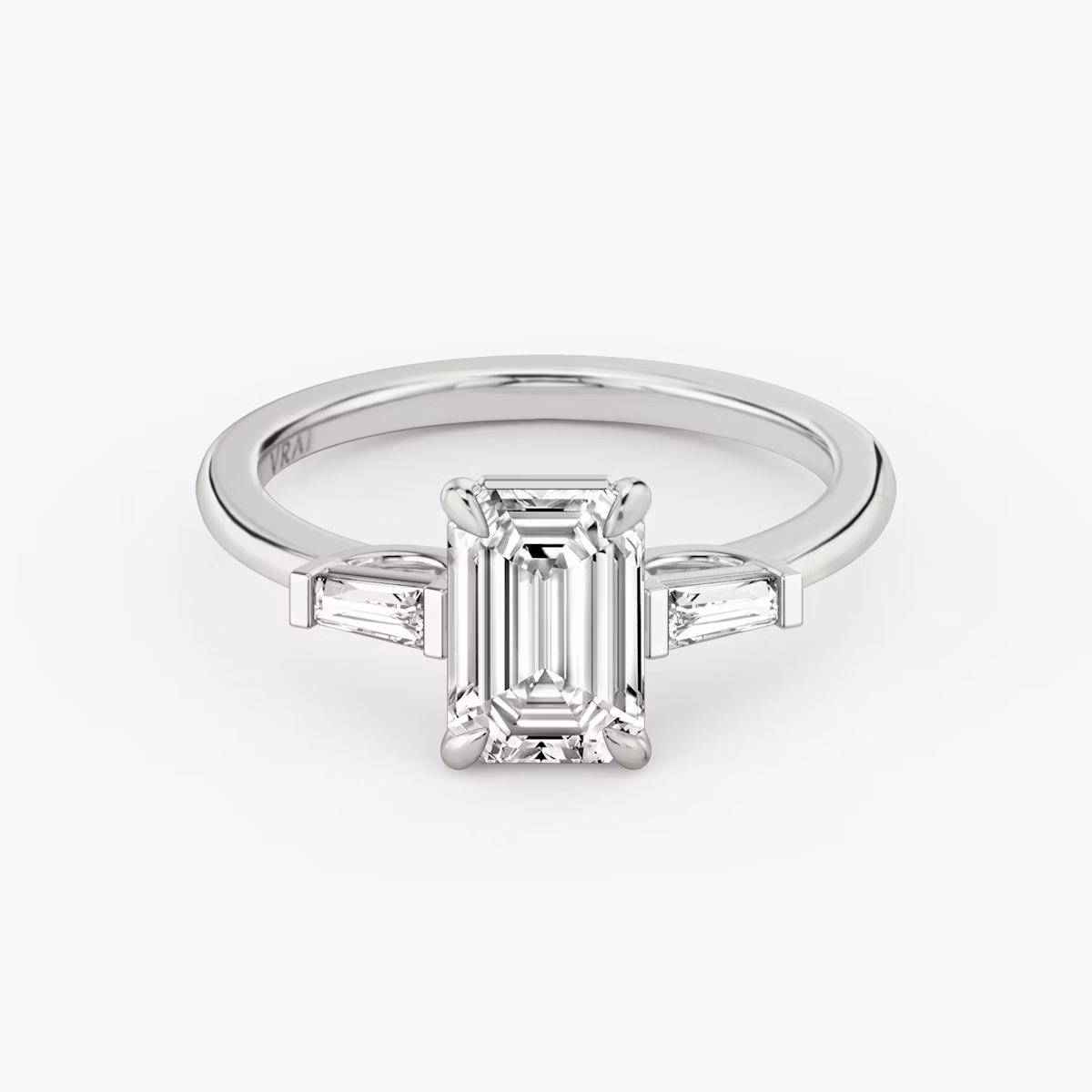 The Three Stone | Emerald | Platinum | bandAccent: Plain | sideStoneCarat: 0.10ct | sideStoneShape: Tapered Baguette | diamondOrientation: vertical | caratWeight: other