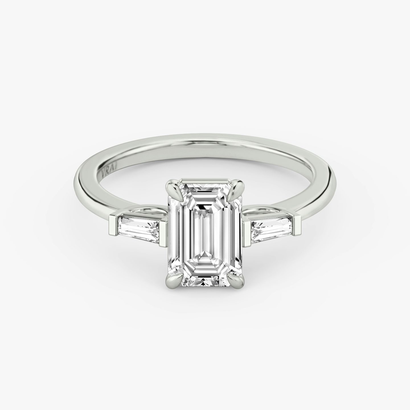 The Three Stone | Emerald | Platinum | bandAccent: Plain | sideStoneCarat: 0.10ct | sideStoneShape: Tapered Baguette | diamondOrientation: vertical | caratWeight: other