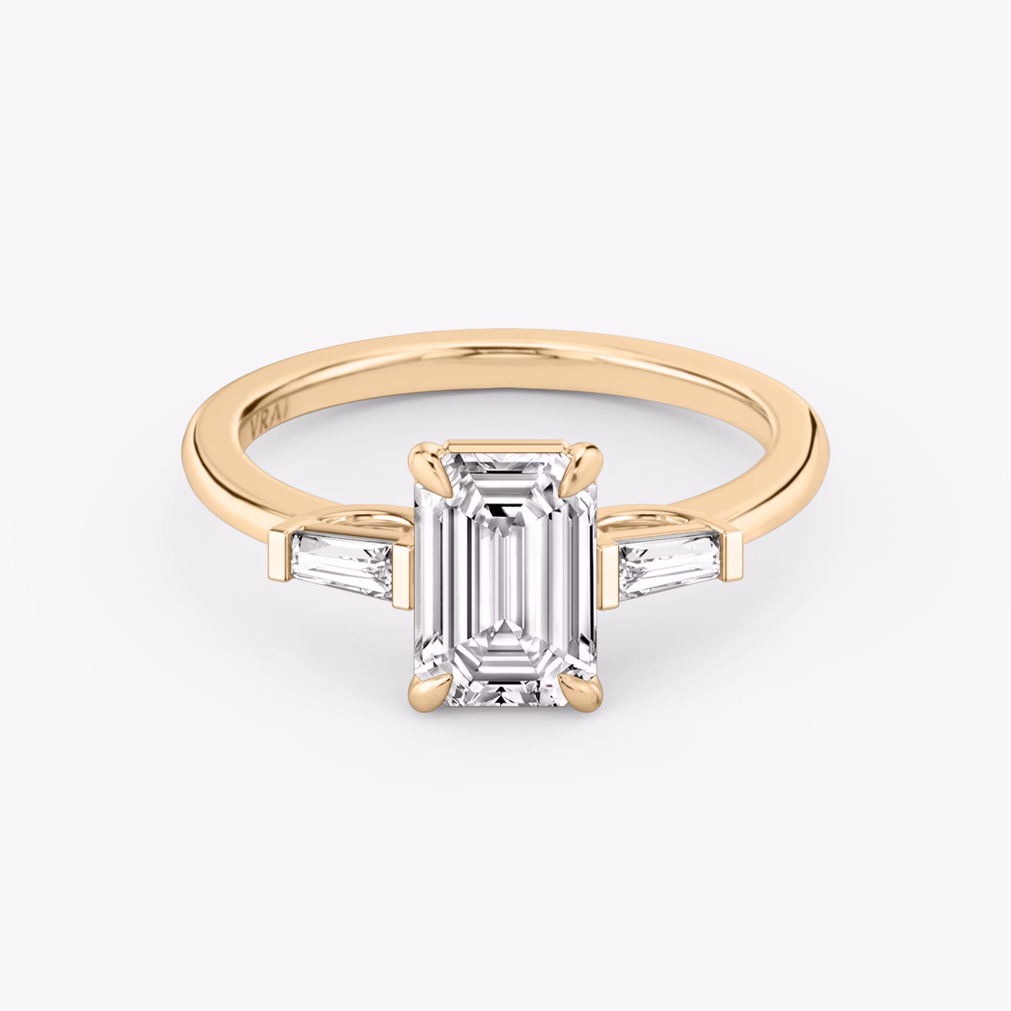 The Three Stone | Emerald | 14k | Rose Gold | bandAccent: Plain | sideStoneCarat: 0.10ct | sideStoneShape: Tapered Baguette | diamondOrientation: vertical | caratWeight: other