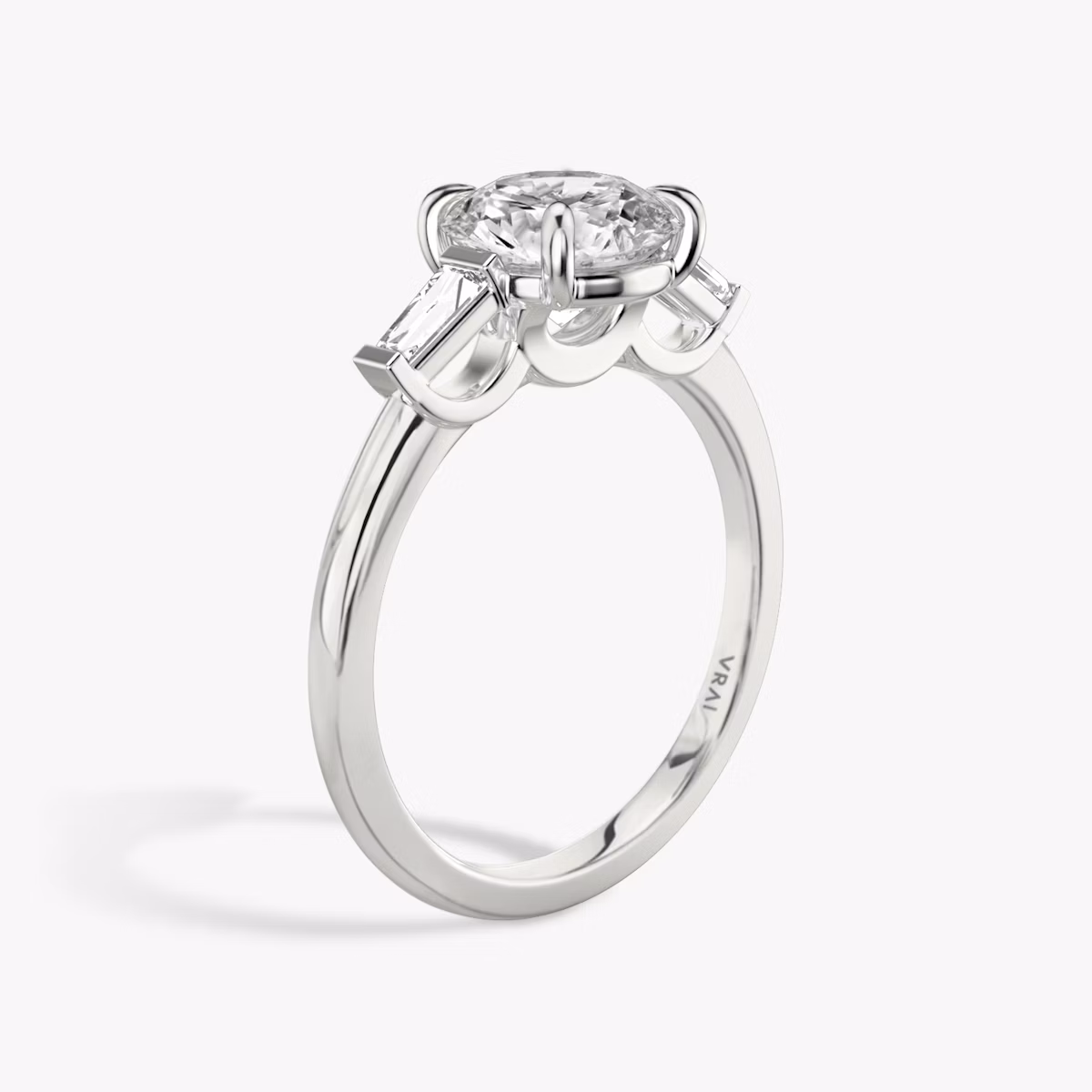 The Three Stone | Round Brilliant | Platinum | bandAccent: Plain | caratWeight: other | sideStoneCarat: 0.10ct | sideStoneShape: Tapered Baguette | diamondOrientation: vertical