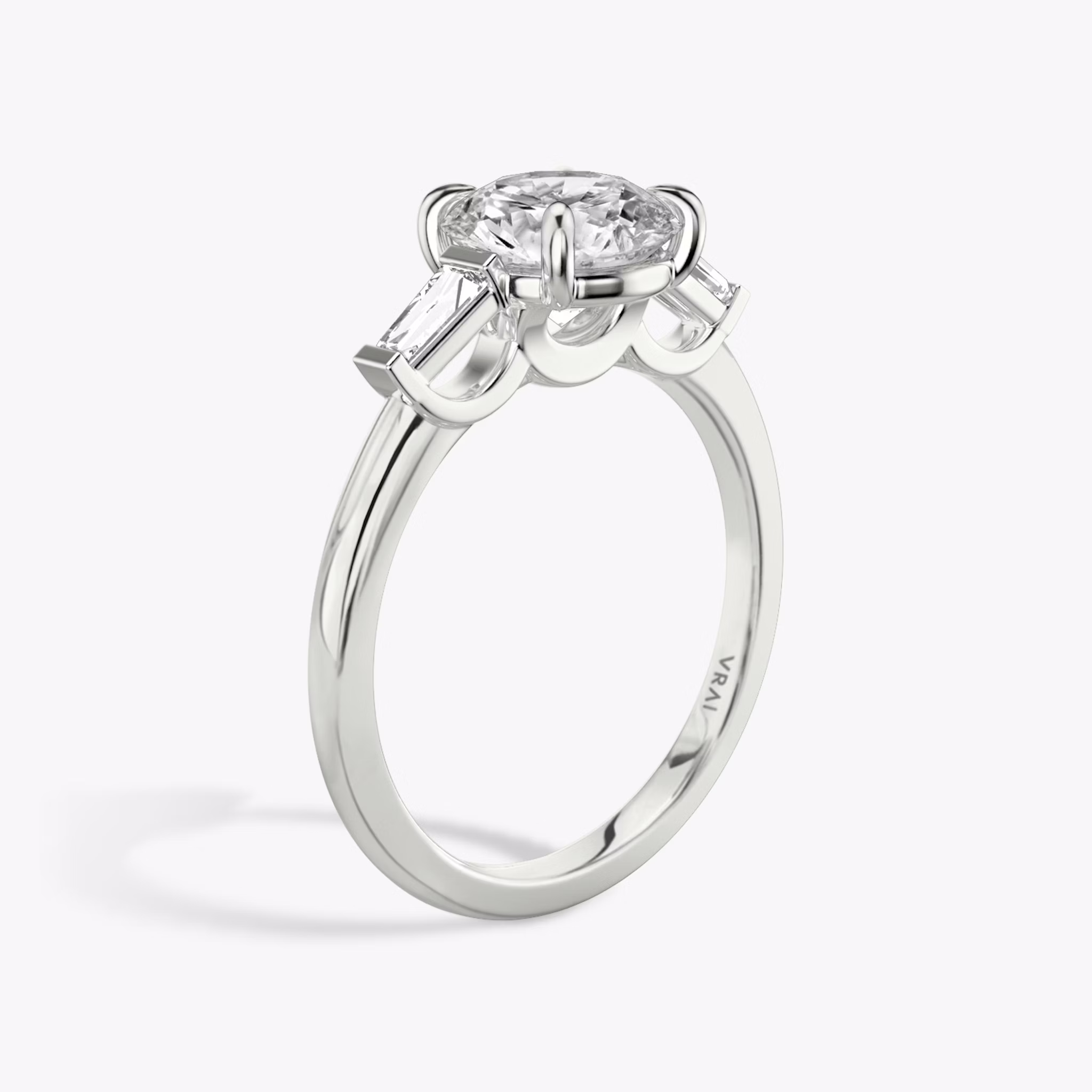 The Three Stone | Round Brilliant | 18k | White Gold | bandAccent: Plain | caratWeight: other | sideStoneCarat: 0.10ct | sideStoneShape: Tapered Baguette | diamondOrientation: vertical