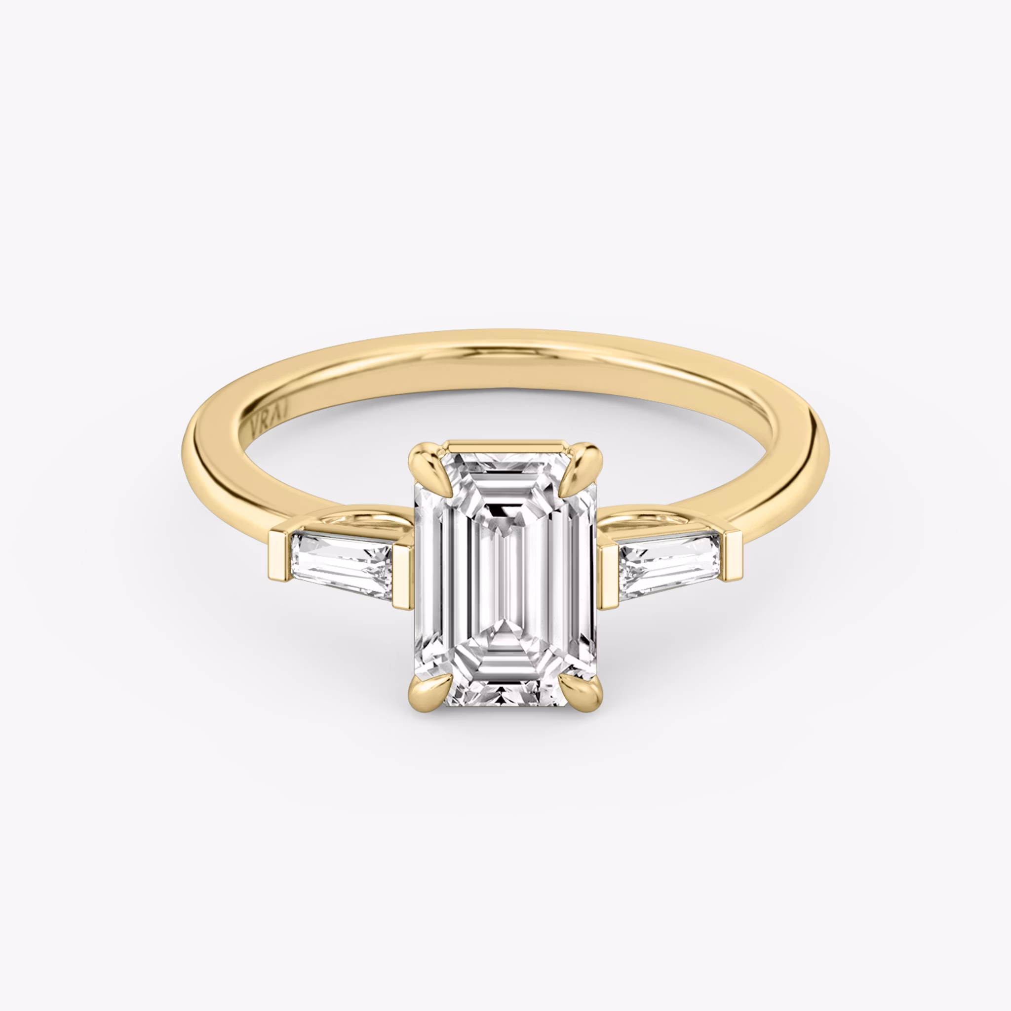 The Three Stone | Emerald | 18k | Yellow Gold | bandAccent: Plain | sideStoneCarat: 0.10ct | sideStoneShape: Tapered Baguette | diamondOrientation: vertical | caratWeight: other