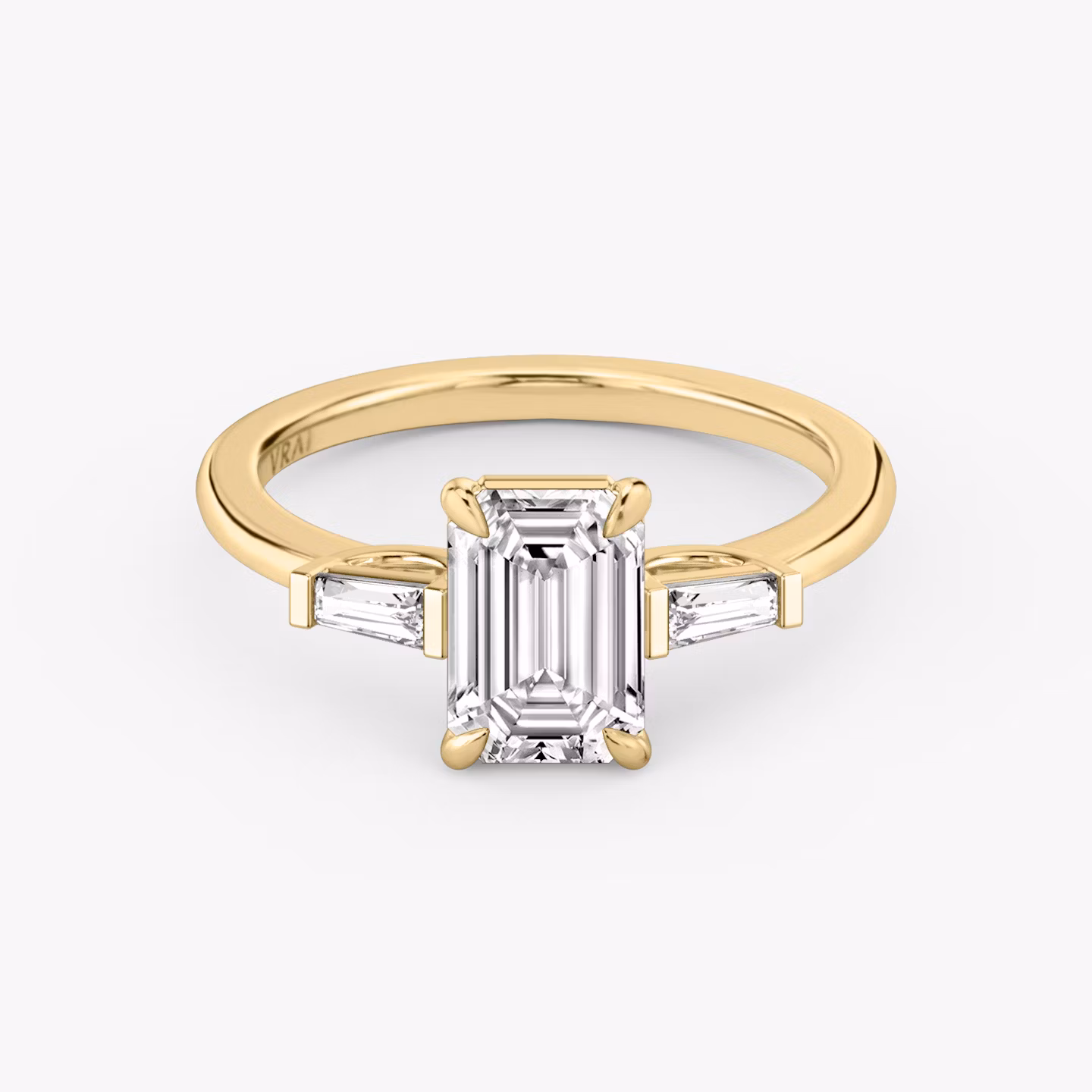 Anillo de compromiso Three Stone | Esmeralda | 18k | Oro amarillo | bandAccent: Simple | sideStoneCarat: 0.10ct | sideStoneShape: Baguette Cónica | diamondOrientation: vertical | caratWeight: other