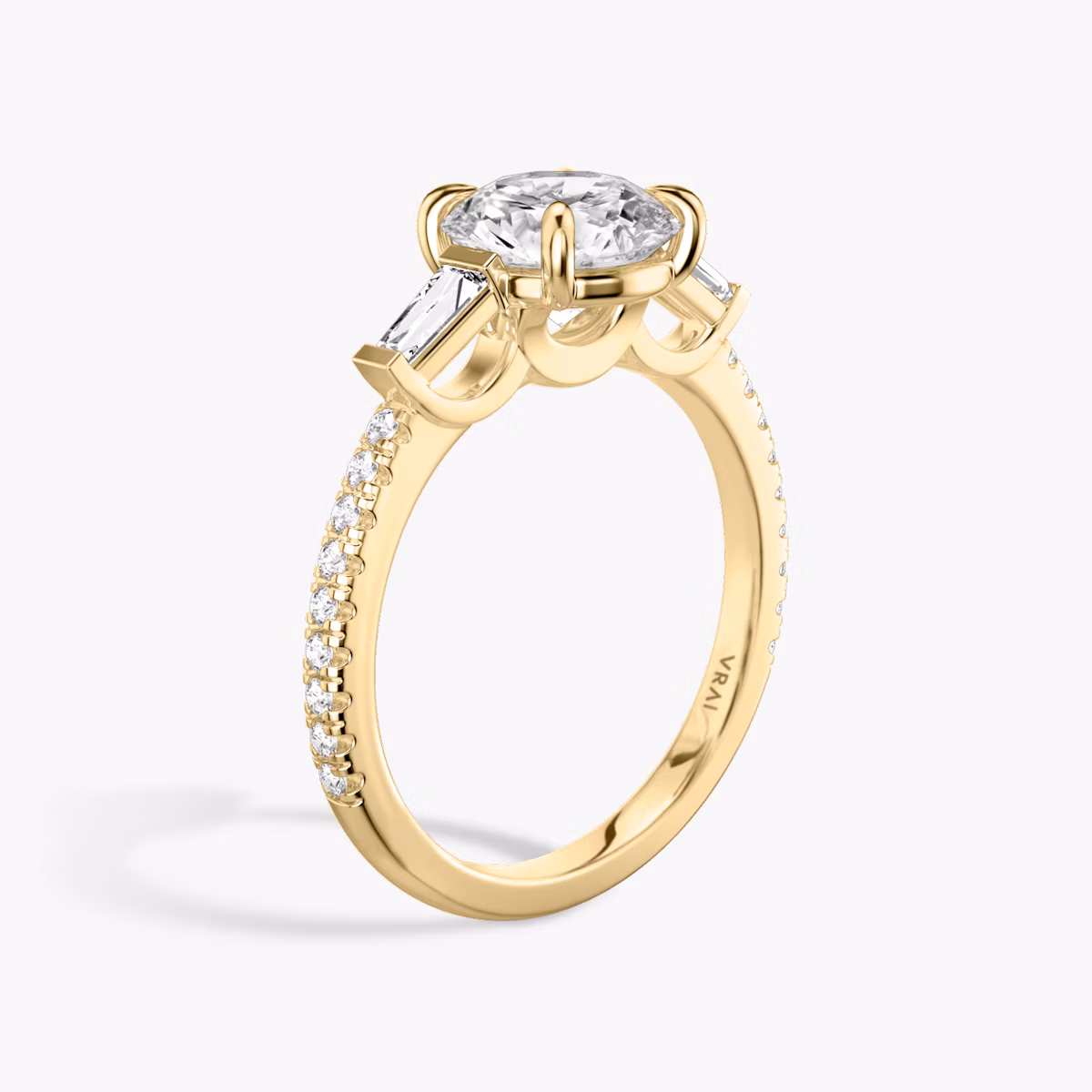 The Three Stone | Round Brilliant | 18k | Yellow Gold | bandAccent: Pavé | caratWeight: other | sideStoneCarat: 0.10ct | sideStoneShape: Tapered Baguette | diamondOrientation: vertical