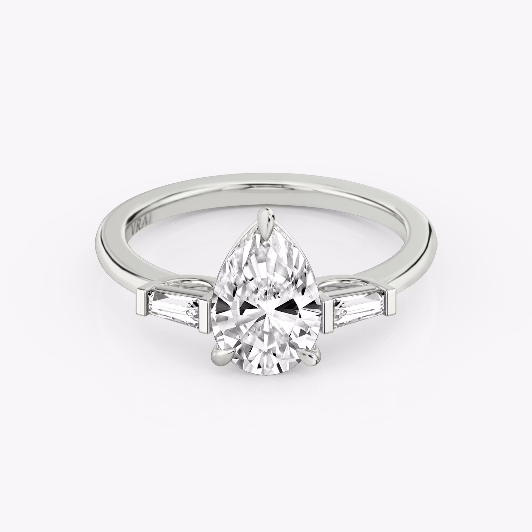 The Three Stone | Pear | Platinum | bandAccent: Plain | sideStoneCarat: 0.10ct | sideStoneShape: Tapered Baguette | diamondOrientation: vertical | caratWeight: other