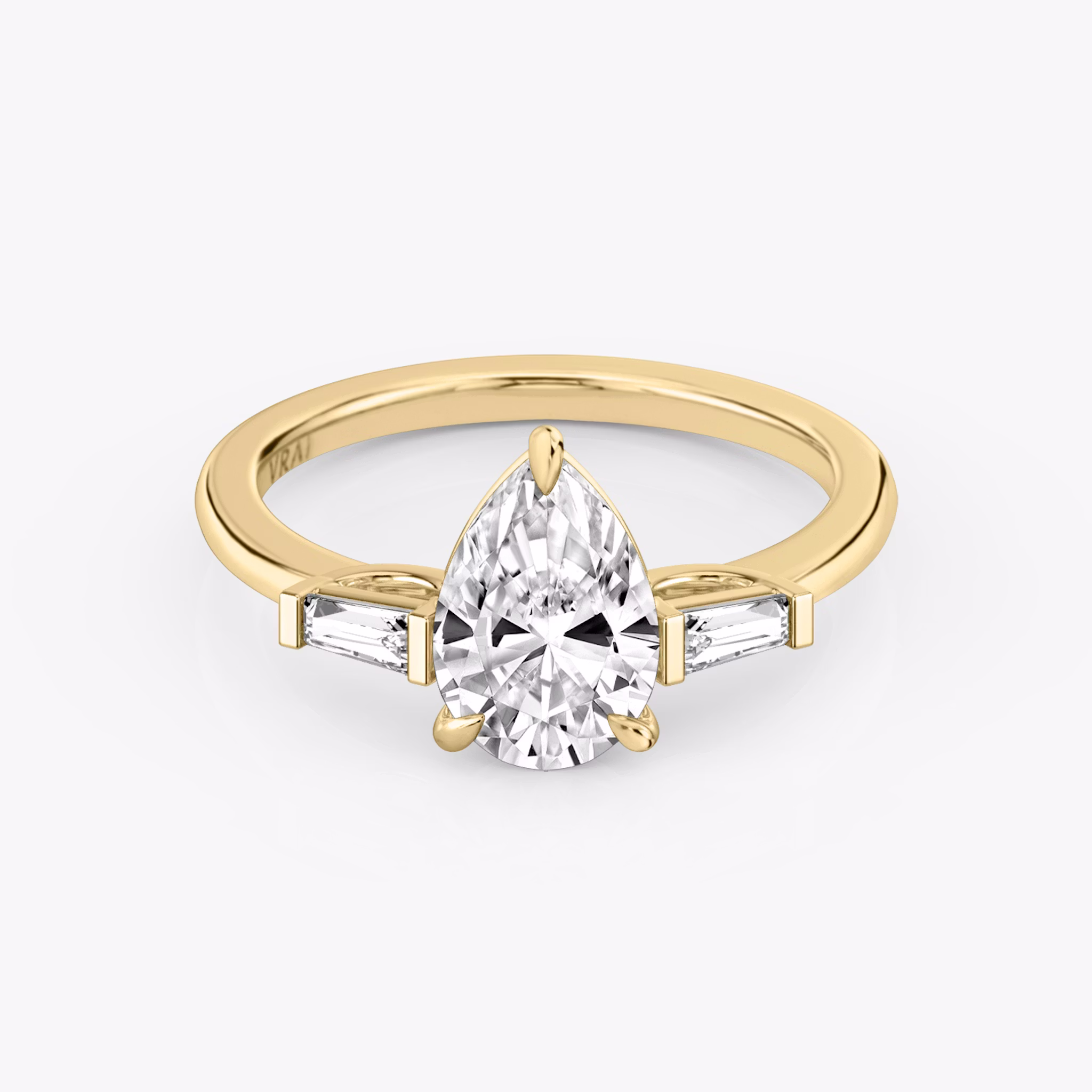 The Three Stone | Pear | 18k | Yellow Gold | bandAccent: Plain | sideStoneCarat: 0.10ct | sideStoneShape: Tapered Baguette | diamondOrientation: vertical | caratWeight: other