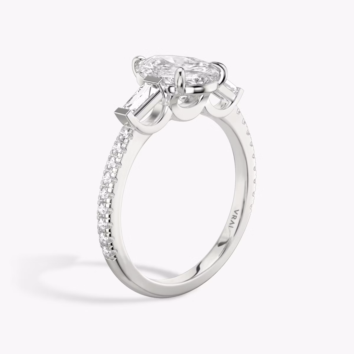 The Three Stone | Pear | 18k | White Gold | bandAccent: Pavé | sideStoneCarat: 0.10ct | sideStoneShape: Tapered Baguette | diamondOrientation: vertical | caratWeight: other