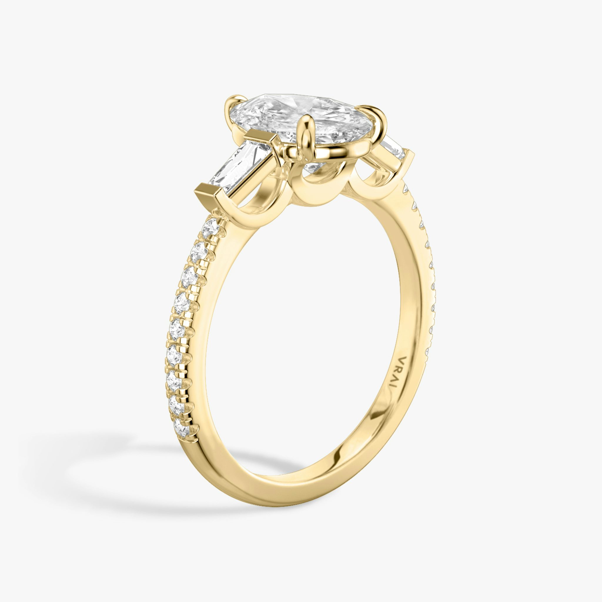 The Three Stone | Pear | 18k | Yellow Gold | bandAccent: Pavé | sideStoneCarat: 0.10ct | sideStoneShape: Tapered Baguette | diamondOrientation: vertical | caratWeight: other