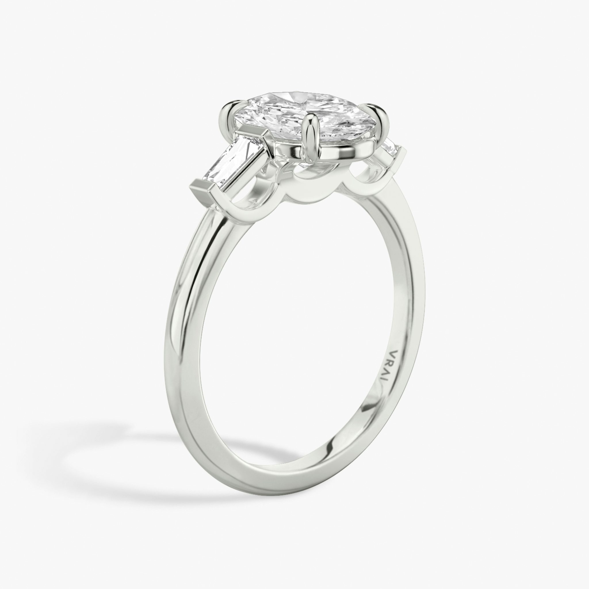The Three Stone | Oval | 18k | White Gold | bandAccent: Plain | sideStoneCarat: 0.10ct | sideStoneShape: Tapered Baguette | diamondOrientation: vertical | caratWeight: other
