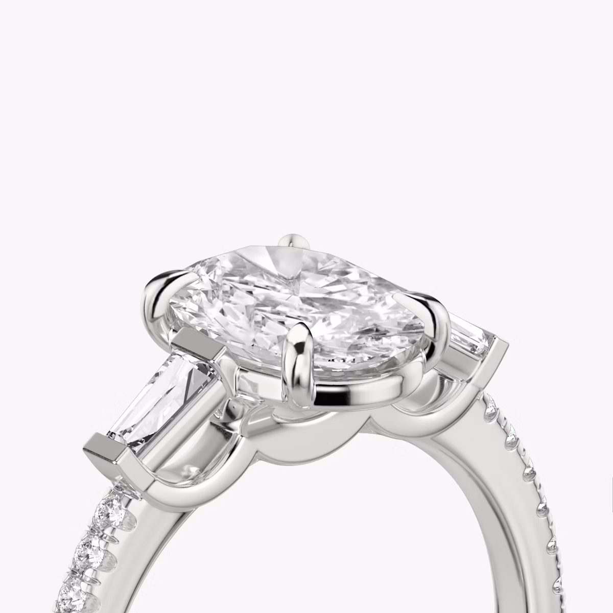 The Three Stone | Oval | Platinum | bandAccent: Pavé | sideStoneCarat: 0.10ct | sideStoneShape: Tapered Baguette | diamondOrientation: vertical | caratWeight: other