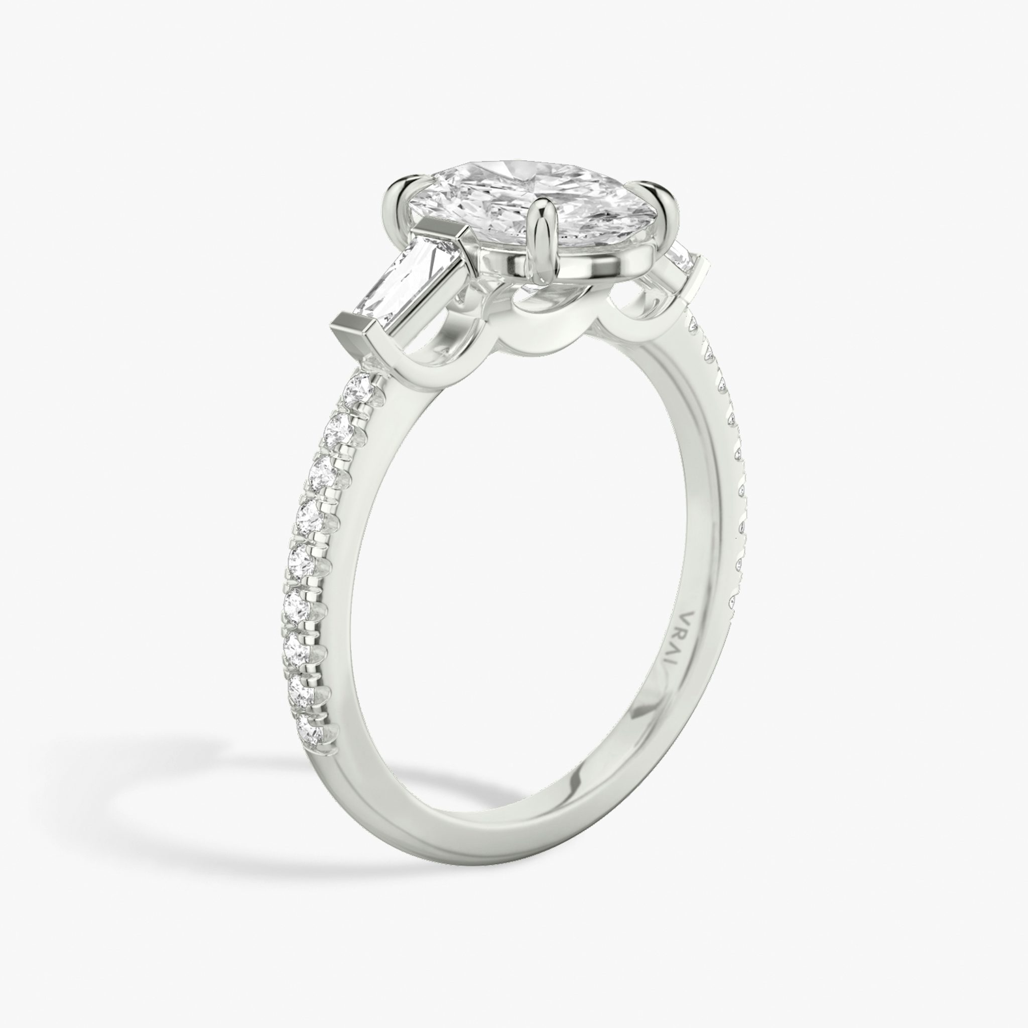 The Three Stone | Oval | 18k | White Gold | bandAccent: Pavé | sideStoneCarat: 0.10ct | sideStoneShape: Tapered Baguette | diamondOrientation: vertical | caratWeight: other