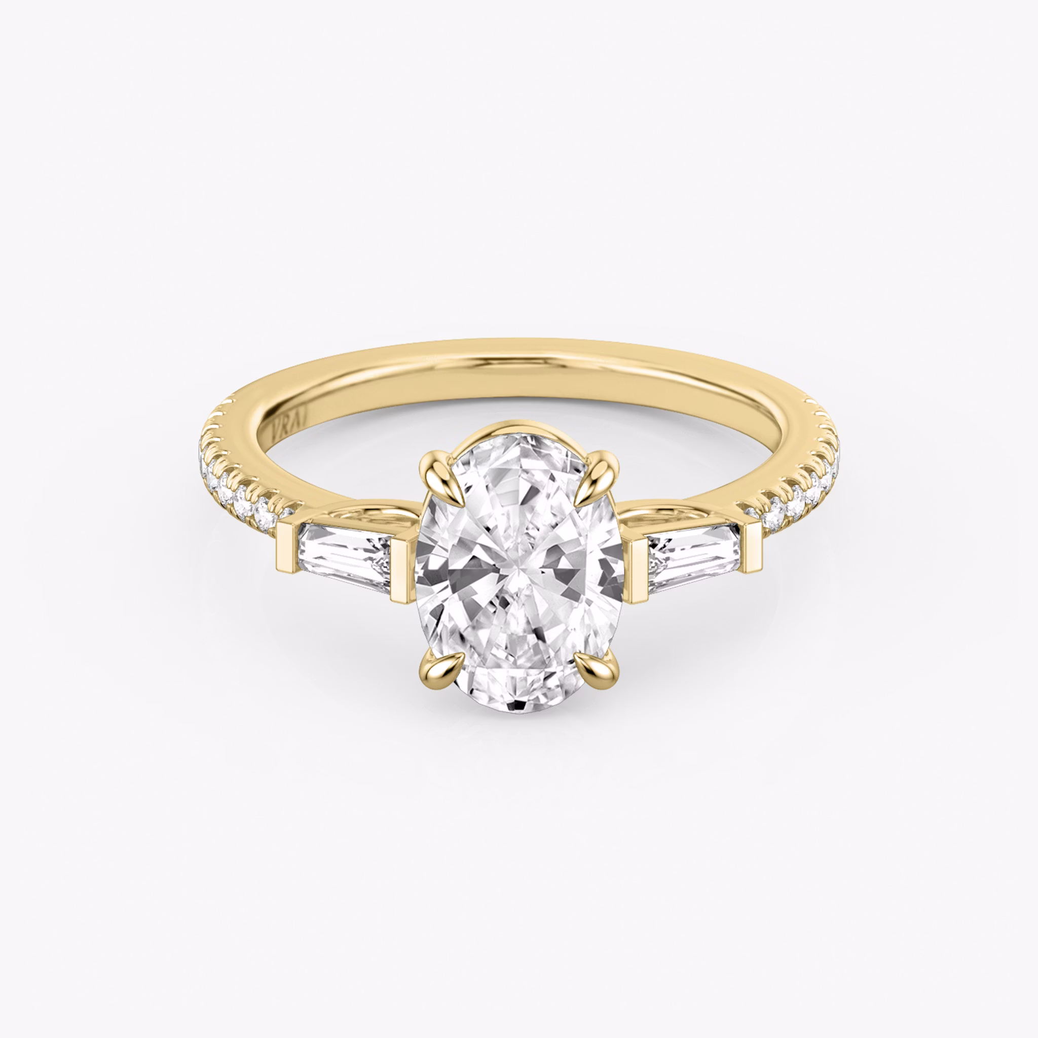 The Three Stone | Oval | 18k | Yellow Gold | bandAccent: Pavé | sideStoneCarat: 0.10ct | sideStoneShape: Tapered Baguette | diamondOrientation: vertical | caratWeight: other