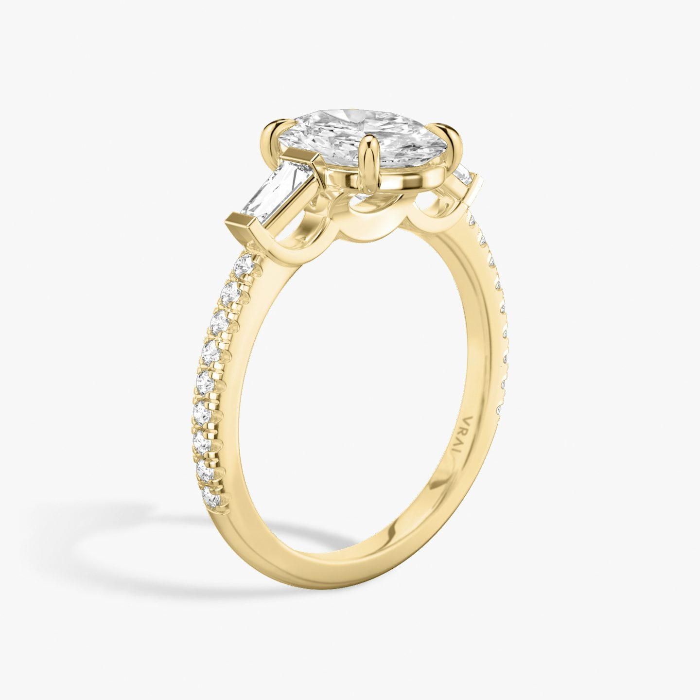 The Three Stone | Oval | 18k | Yellow Gold | bandAccent: Pavé | sideStoneCarat: 0.10ct | sideStoneShape: Tapered Baguette | diamondOrientation: vertical | caratWeight: other