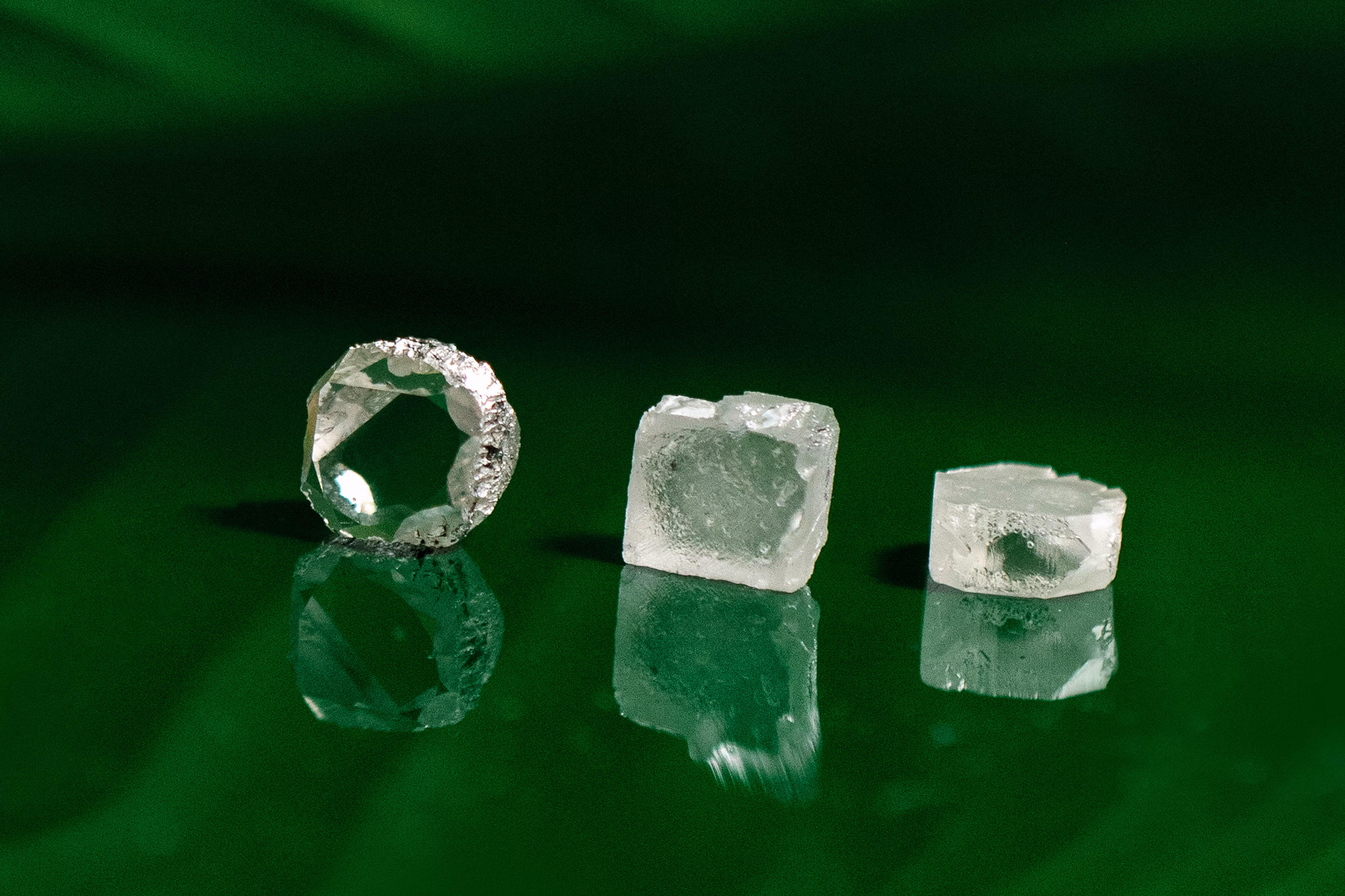 Three real diamond cuts on a green background