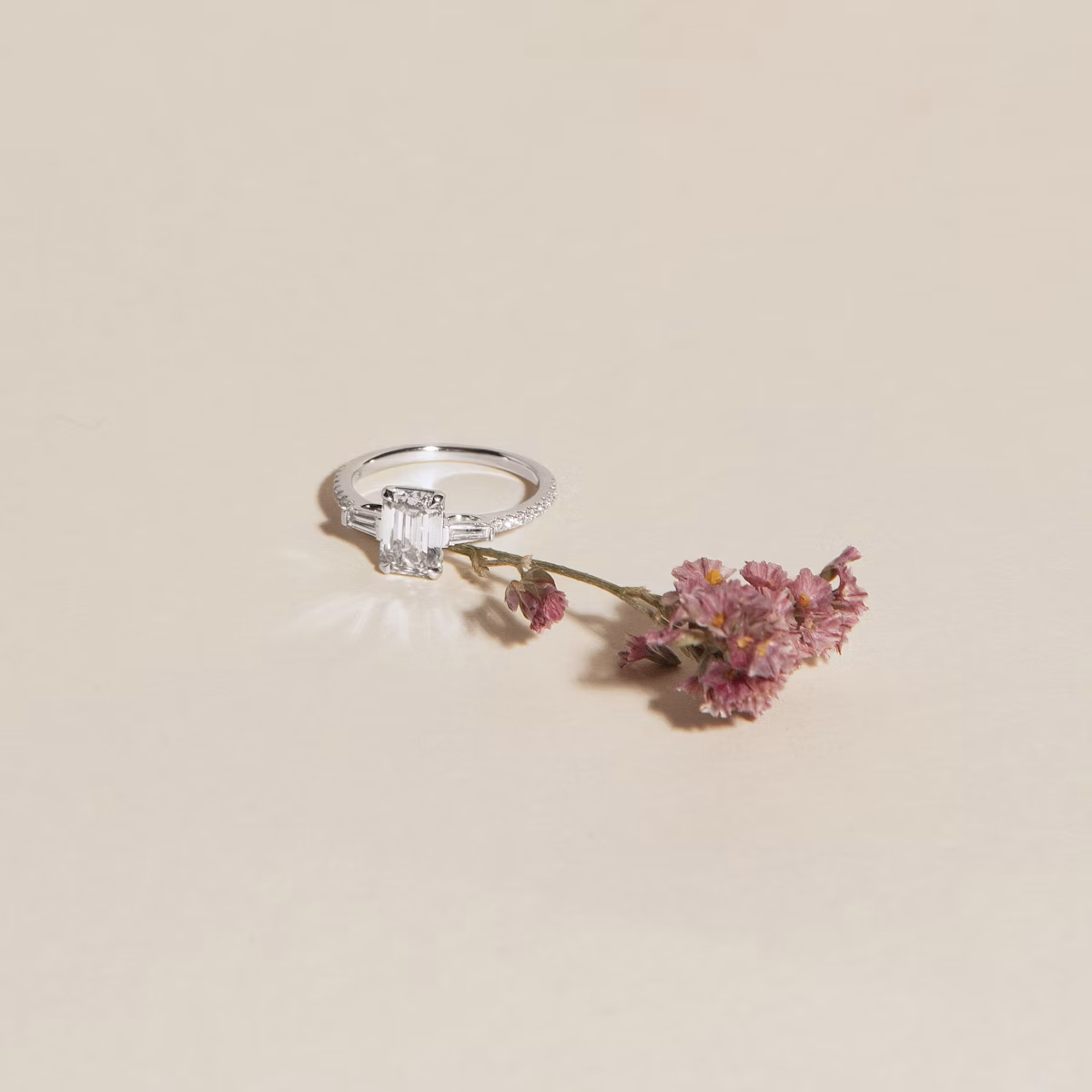 The Three Stone | Emerald | Platinum | bandAccent: Plain | sideStoneCarat: 0.10ct | sideStoneShape: Tapered Baguette | diamondOrientation: vertical | caratWeight: other