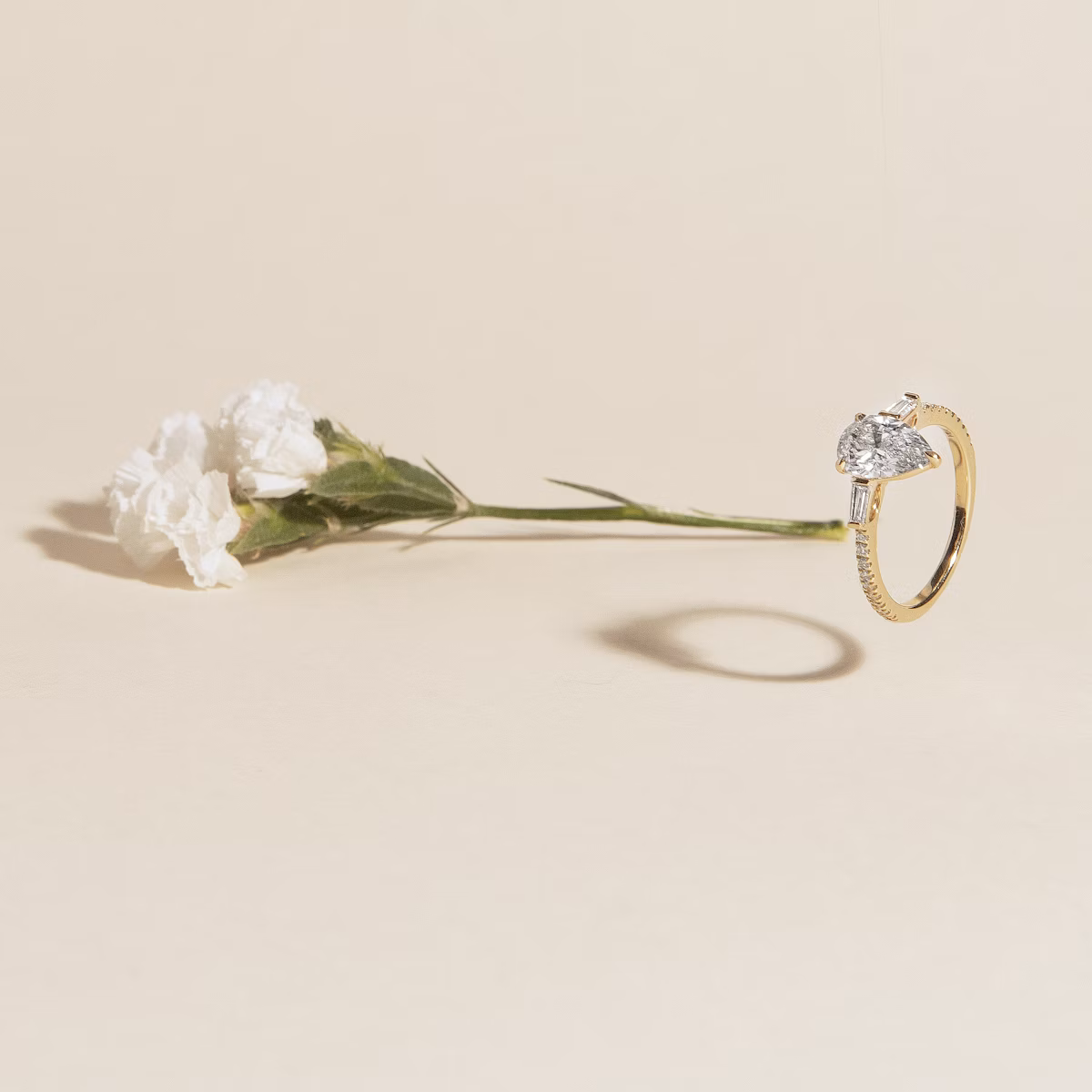 The Three Stone | Pear | 18k | Yellow Gold | bandAccent: Plain | sideStoneCarat: 0.10ct | sideStoneShape: Tapered Baguette | diamondOrientation: vertical | caratWeight: other